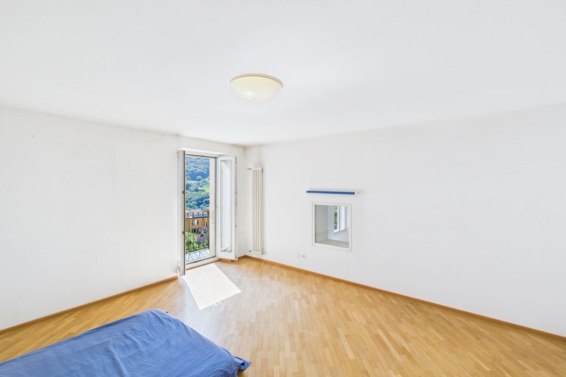 Helles, leeres Schlafzimmer mit Balkonzugang