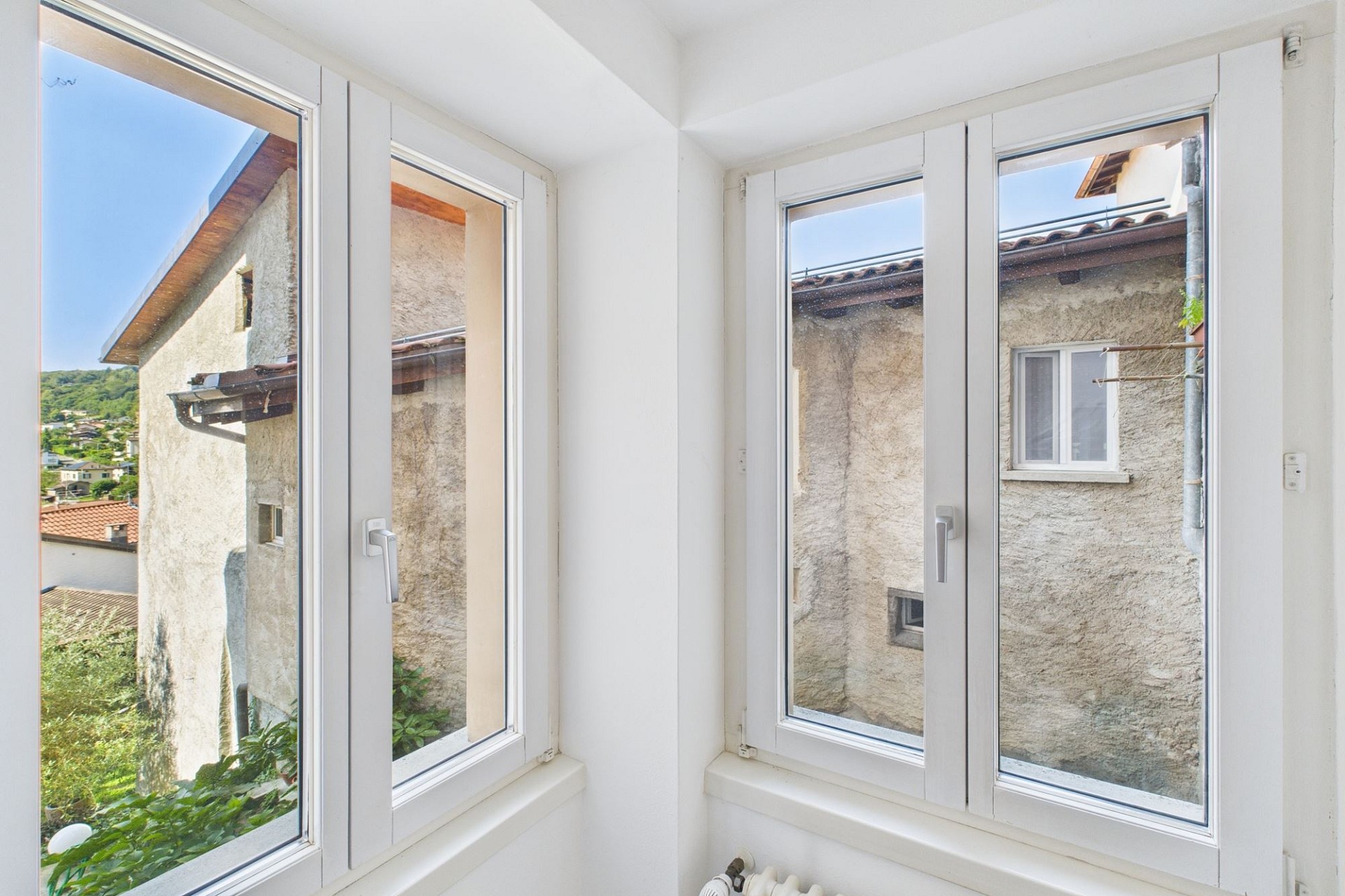 Heller Innenraum mit mehreren Fenstern und Blick ins Freie