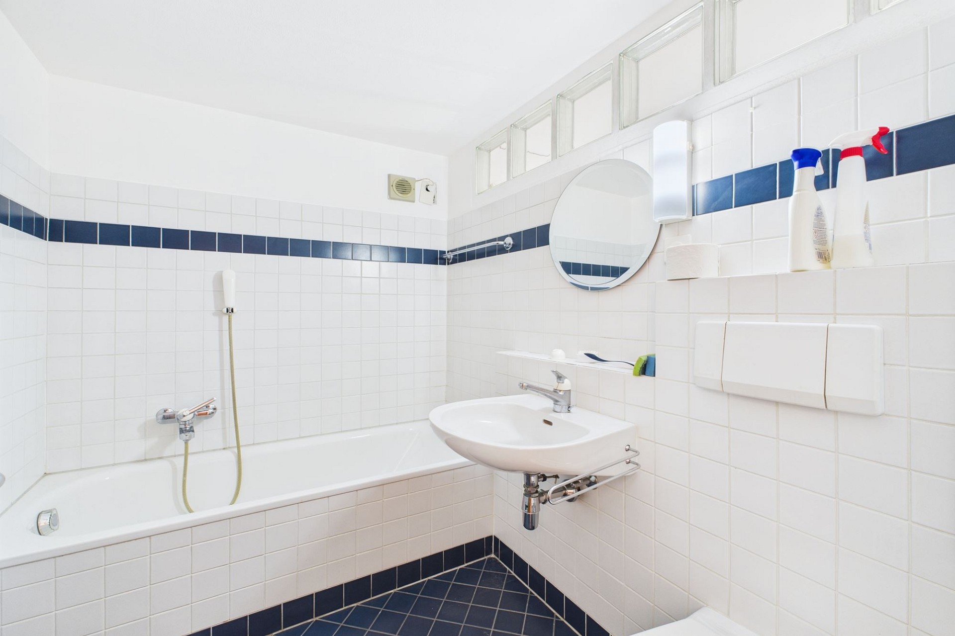 Badezimmer mit Wanne und blau-weißer Fliesenverkleidung