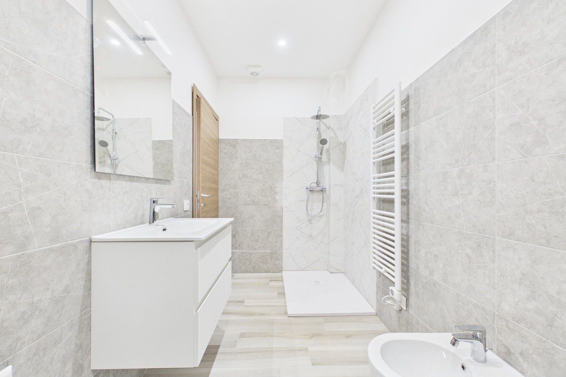 Modernes, helles Badezimmer mit Dusche und Waschtisch