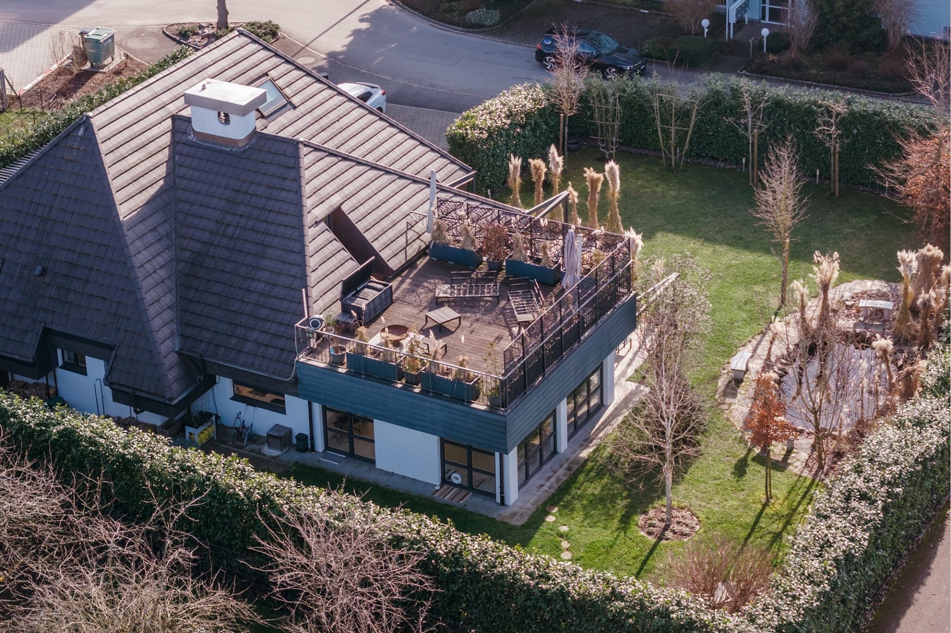 Luftaufnahme eines Hauses mit Dachterrasse und Garten