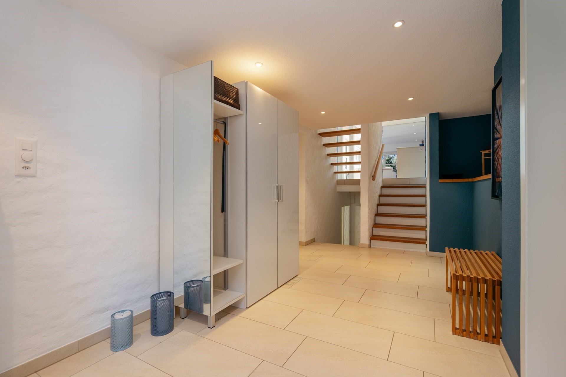 Heller Eingangsbereich mit Treppe und Garderobenschrank