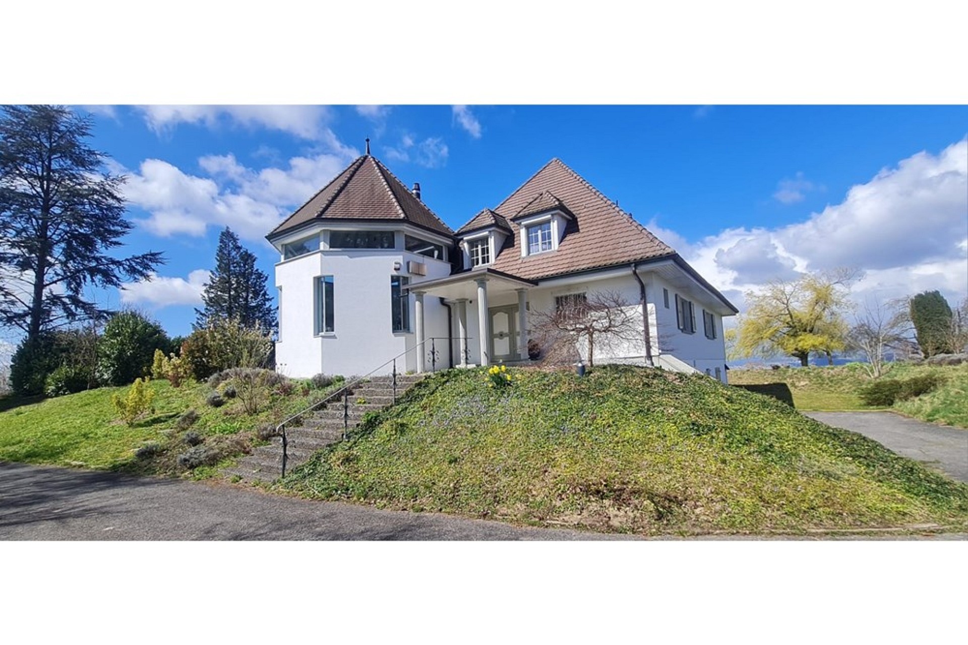 Außenansicht eines freistehenden Hauses mit Turm und Satteldach
