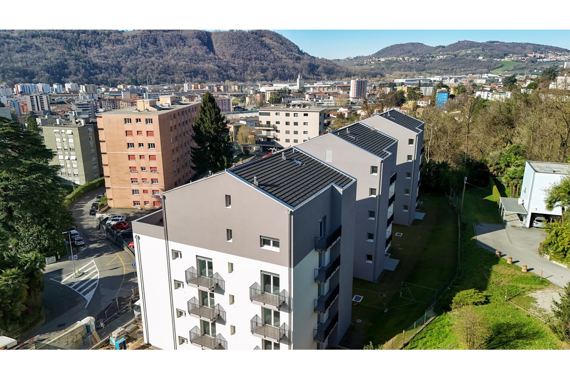 Luftaufnahme eines modernen Mehrfamilienhauses in Hanglage
