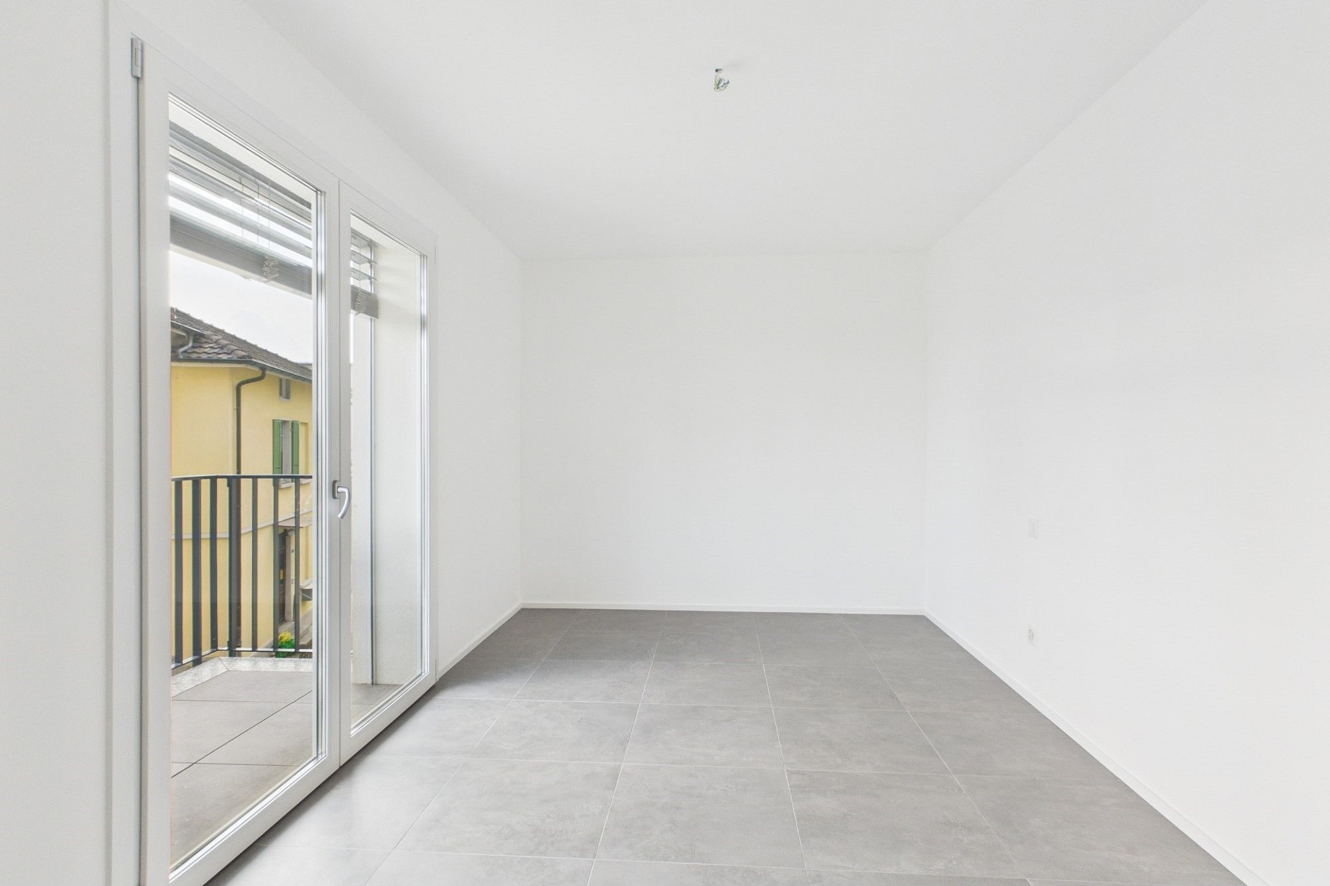 Helles, leeres Zimmer mit Balkonzugang