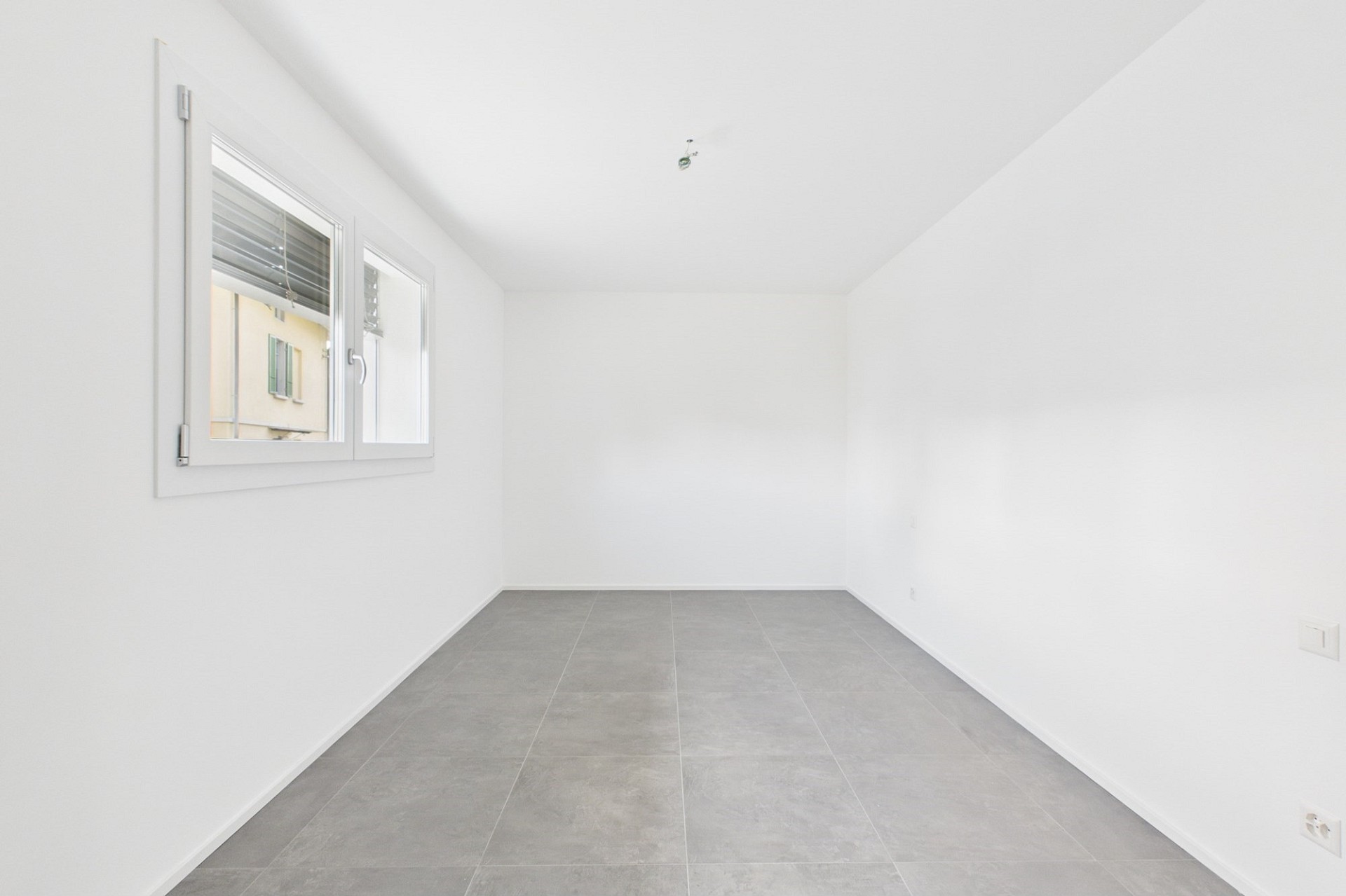 Heller leerer Raum mit Fliesenboden und Fenster