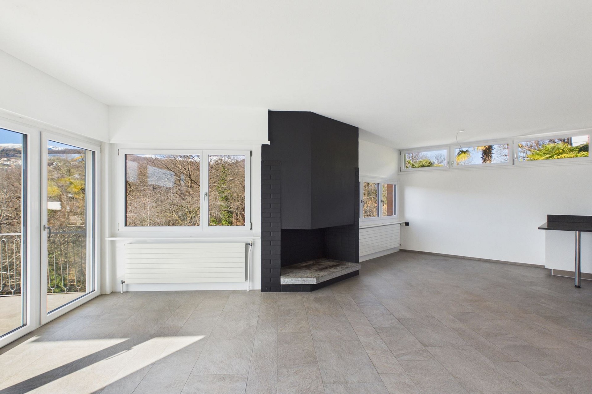 Heller Wohnraum mit Kamin und vielen Fenstern