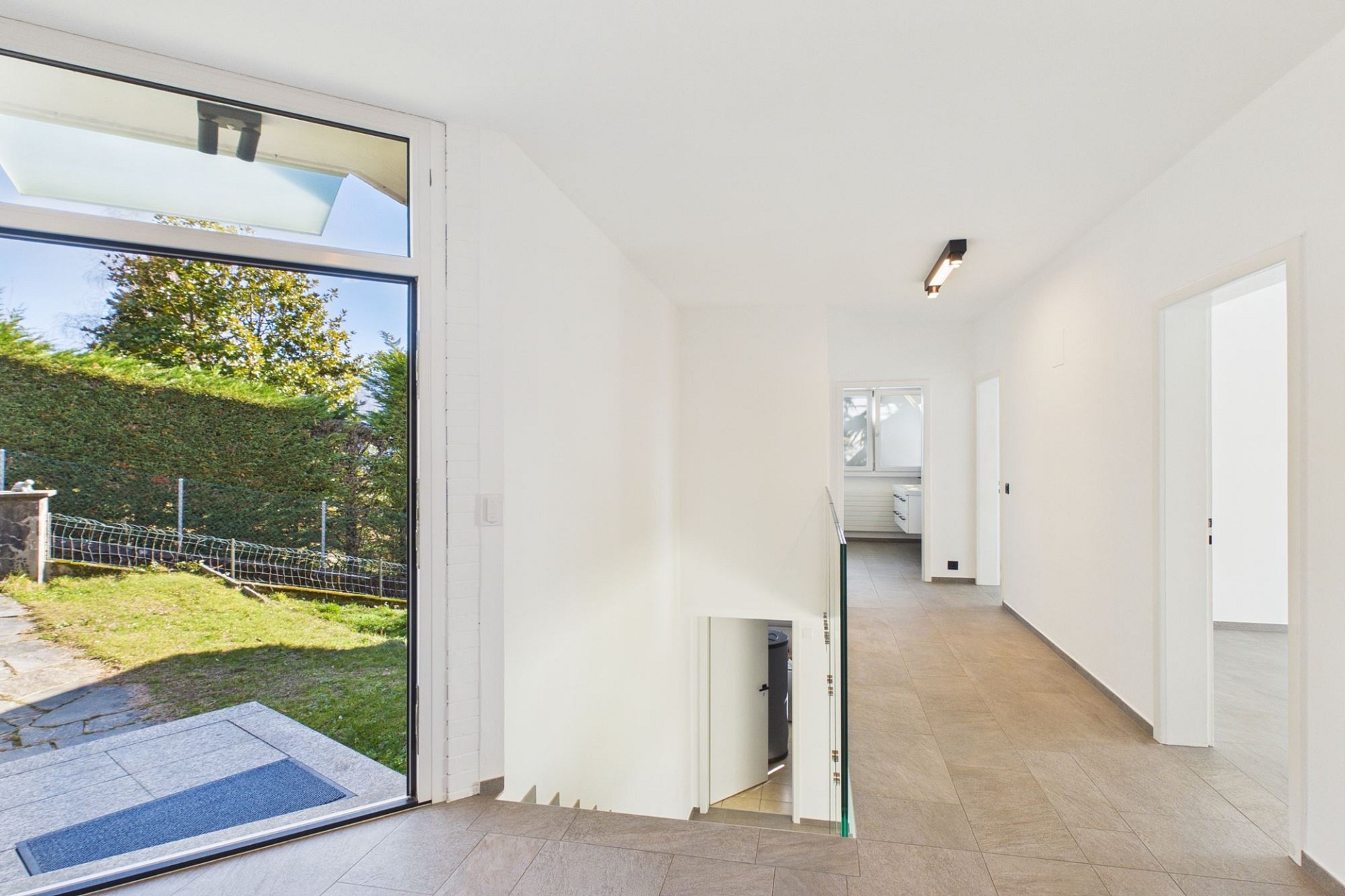 Heller Eingangsbereich mit Treppe und Gartenausgang