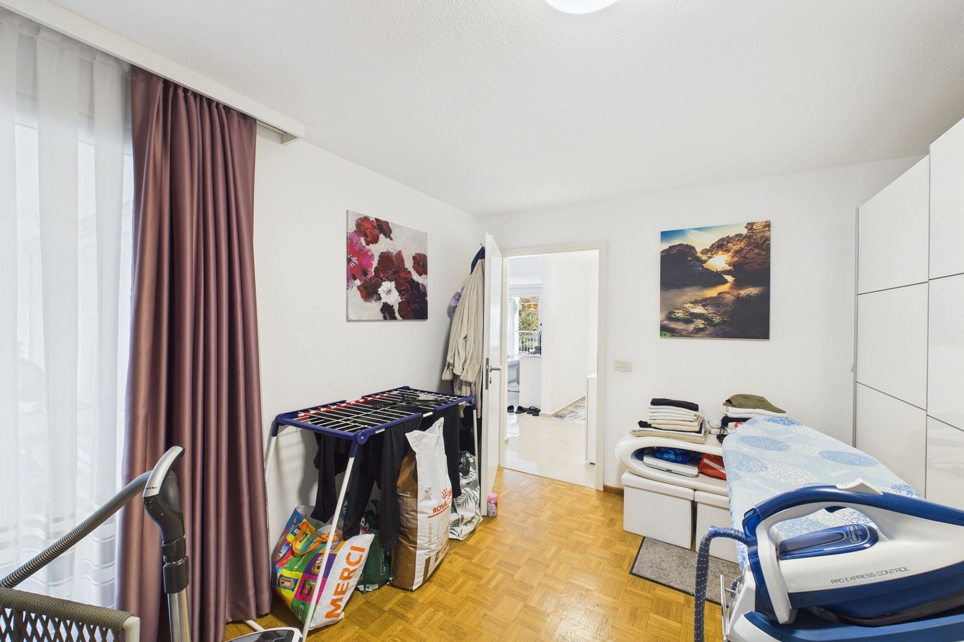 Helles Schlafzimmer mit Arbeits- und Wäscheständerbereich
