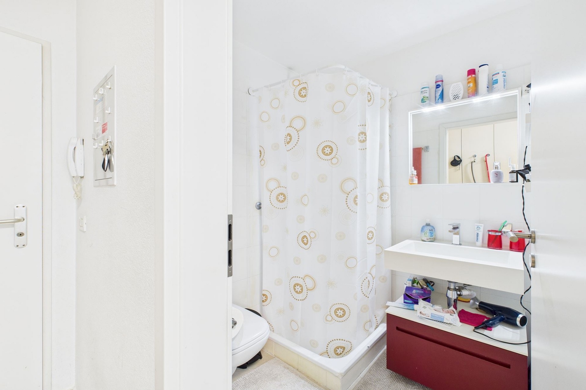 Kleines helles Badezimmer mit Dusche und Waschtisch