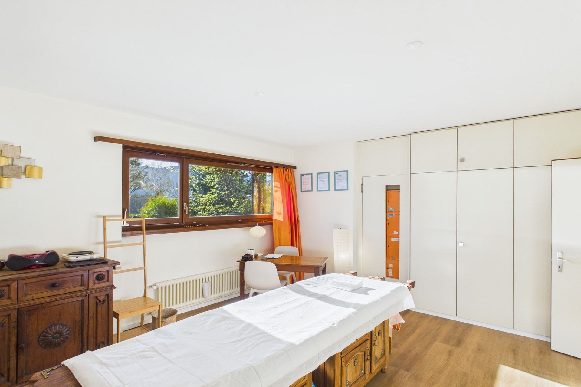 Helles Schlafzimmer mit großem Fenster und Einbauschrank