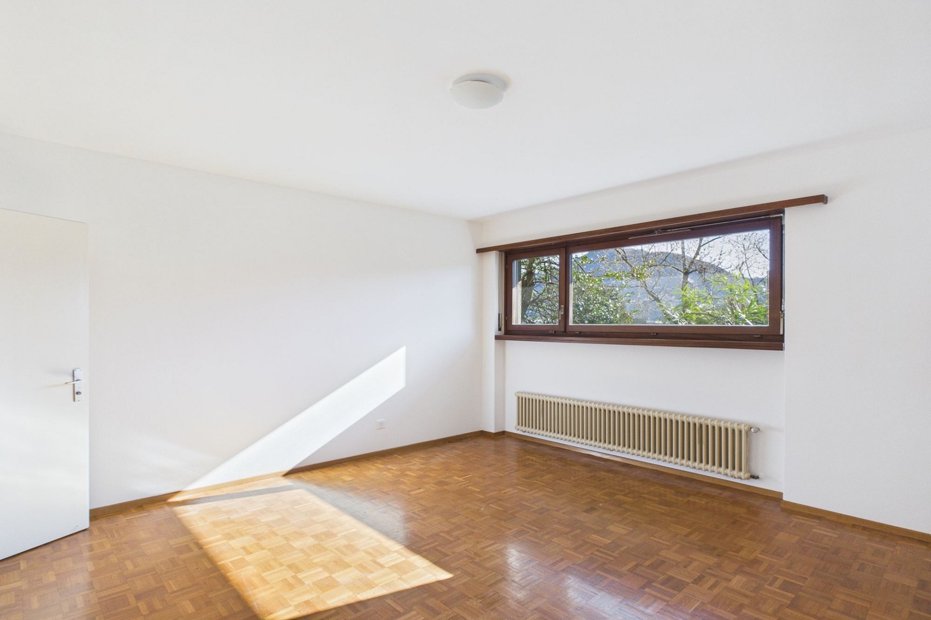 Heller leerer Raum mit Holzfenster und Heizkörper