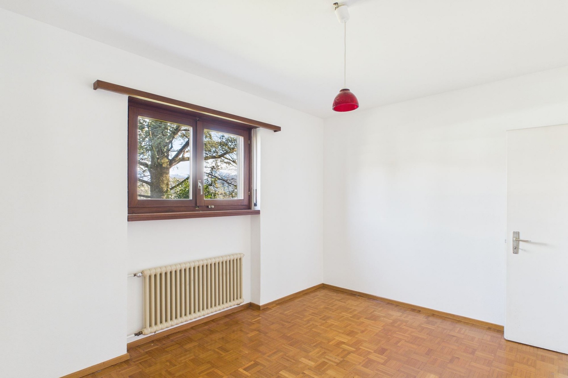 Leeres Zimmer mit Holzparkett und Fenster