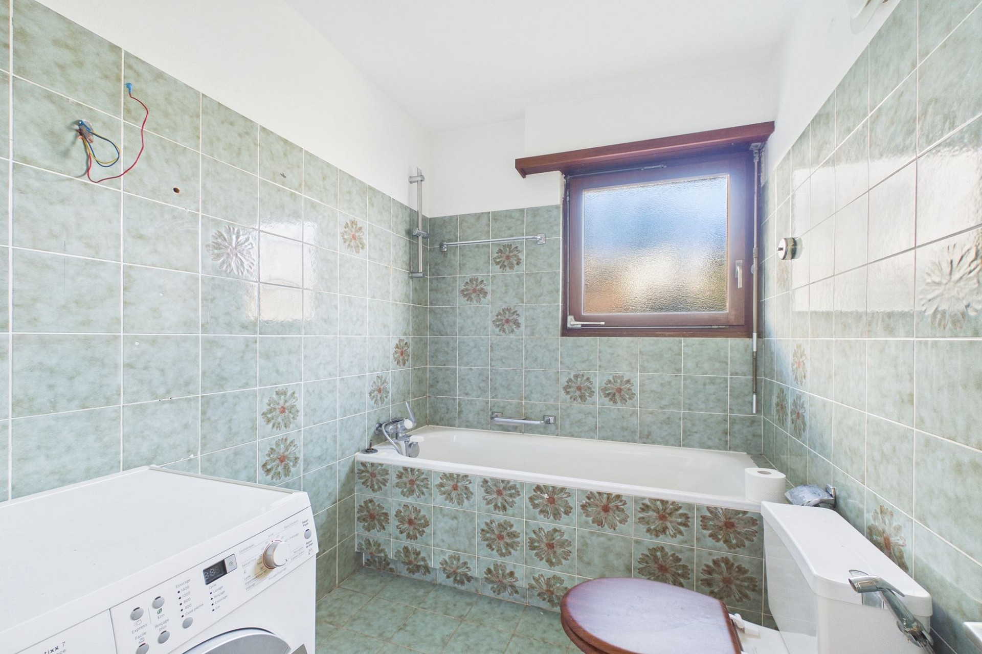 Badezimmer mit Badewanne und Waschmaschine
