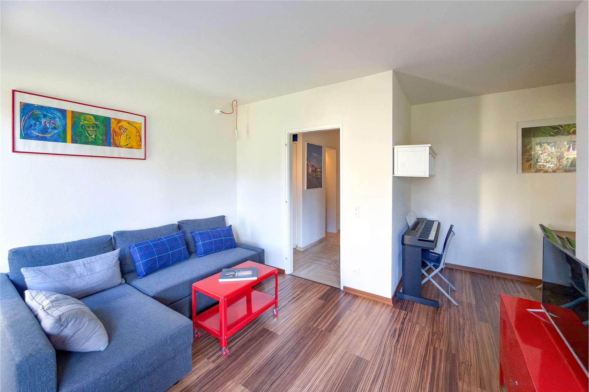 Helles Wohnzimmer mit Sofa und Arbeitsbereich