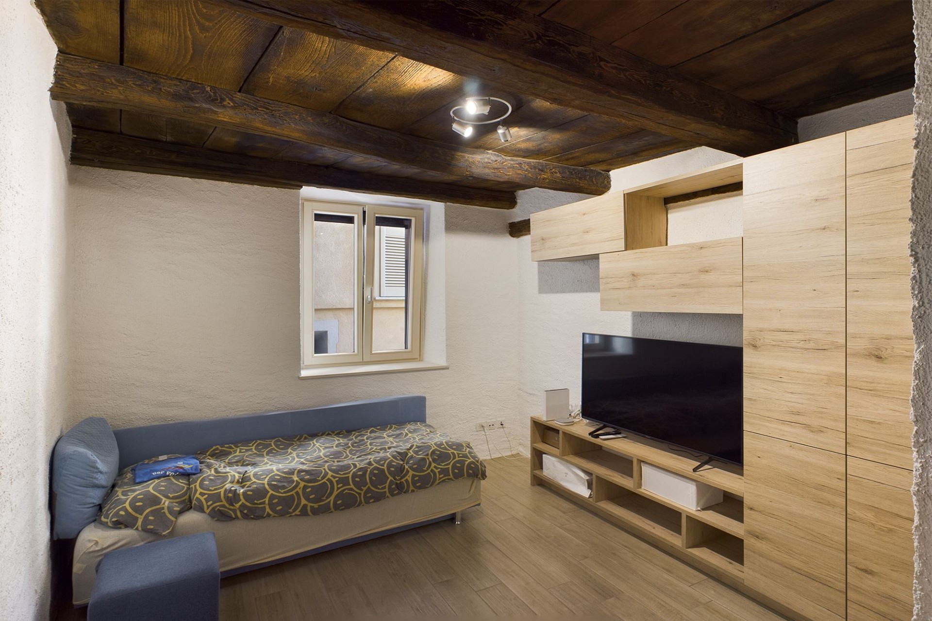 Kleines Schlafzimmer mit rustikaler Holzdecke