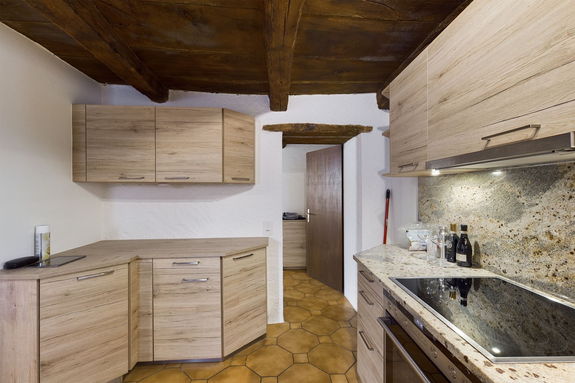 Rustikale Küche mit Holzbalken und Naturstein