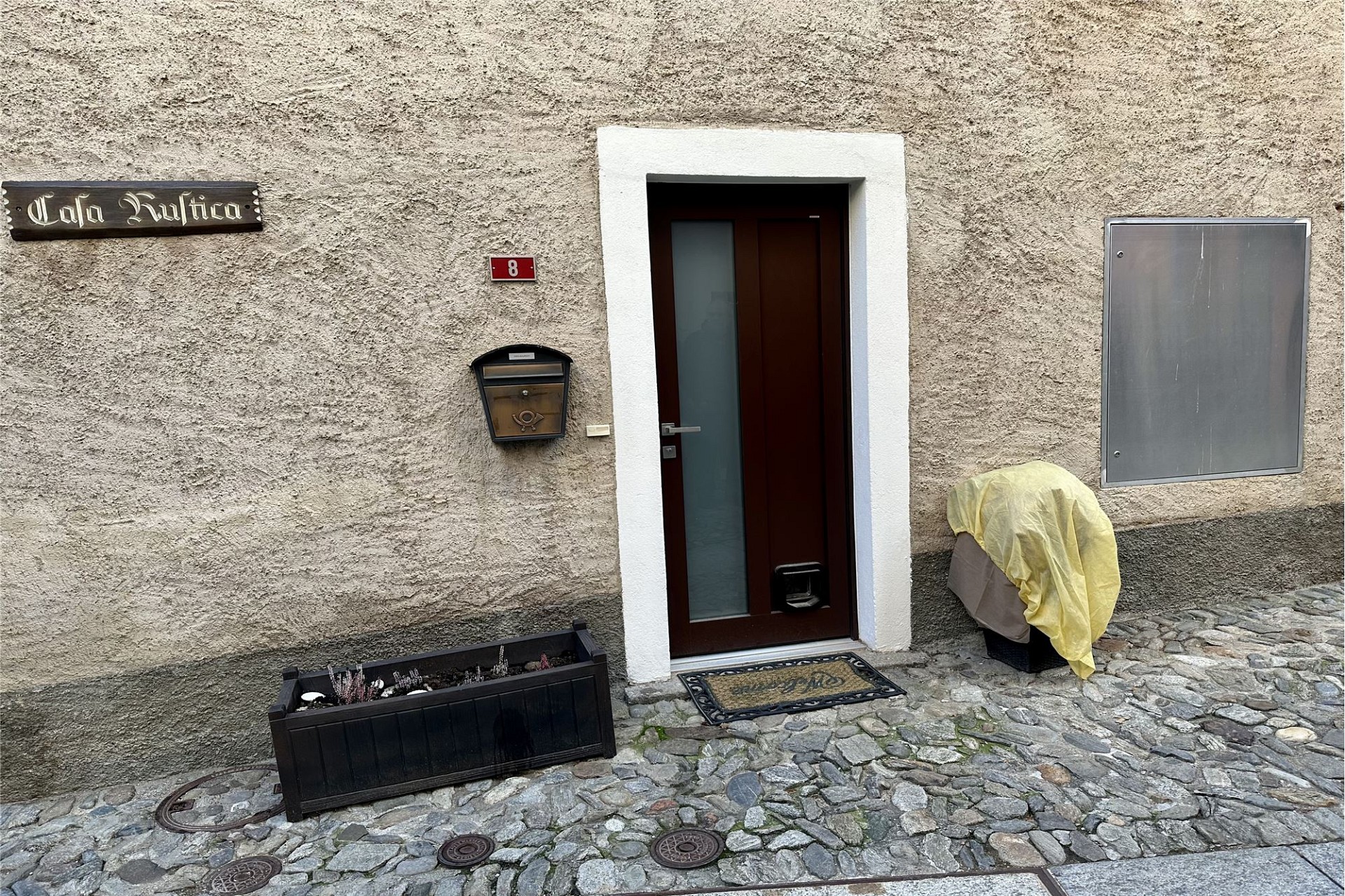 Außenansicht eines Hauseingangs mit Natursteinpflaster