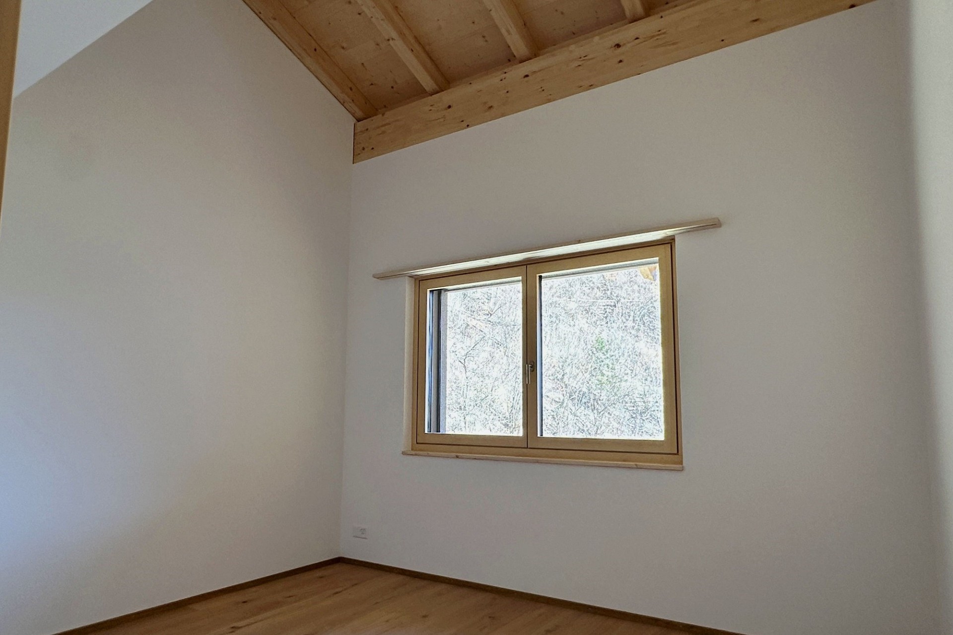 Heller leerer Raum mit Holzdecke und Fenster