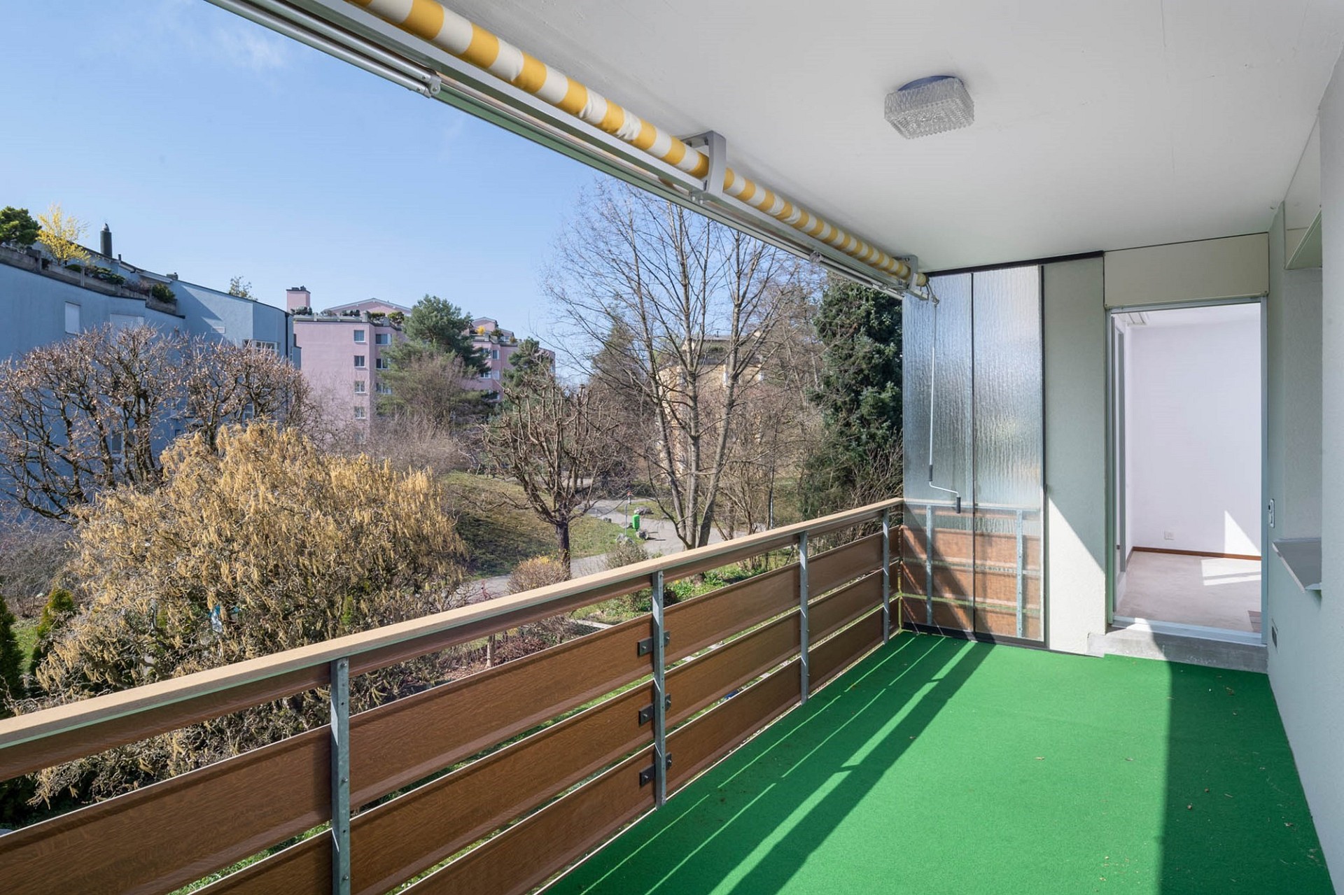 Überdachter Balkon mit Ausblick ins Grüne