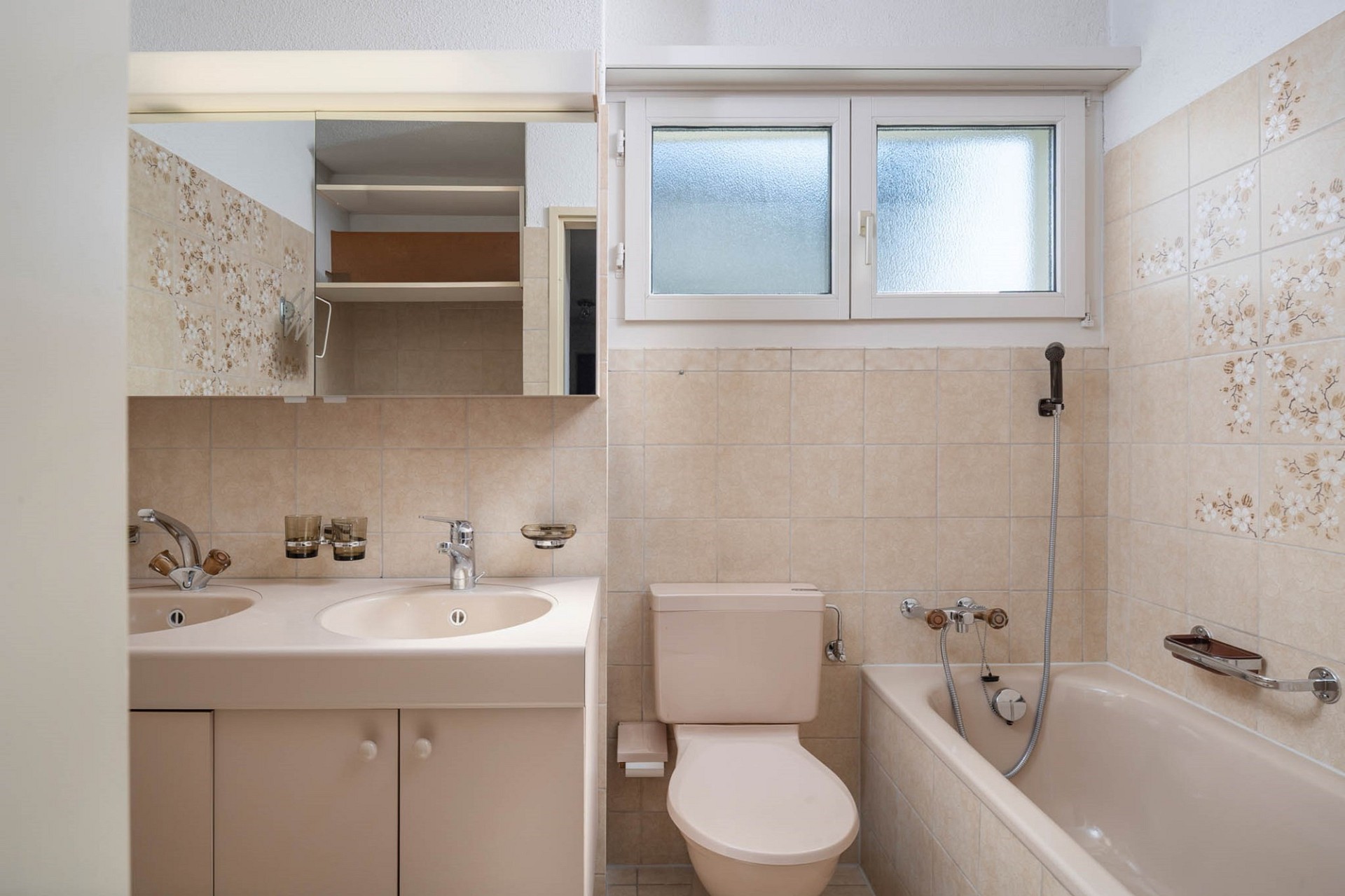 Kleines Badezimmer mit Badewanne, WC und Doppelwaschtisch