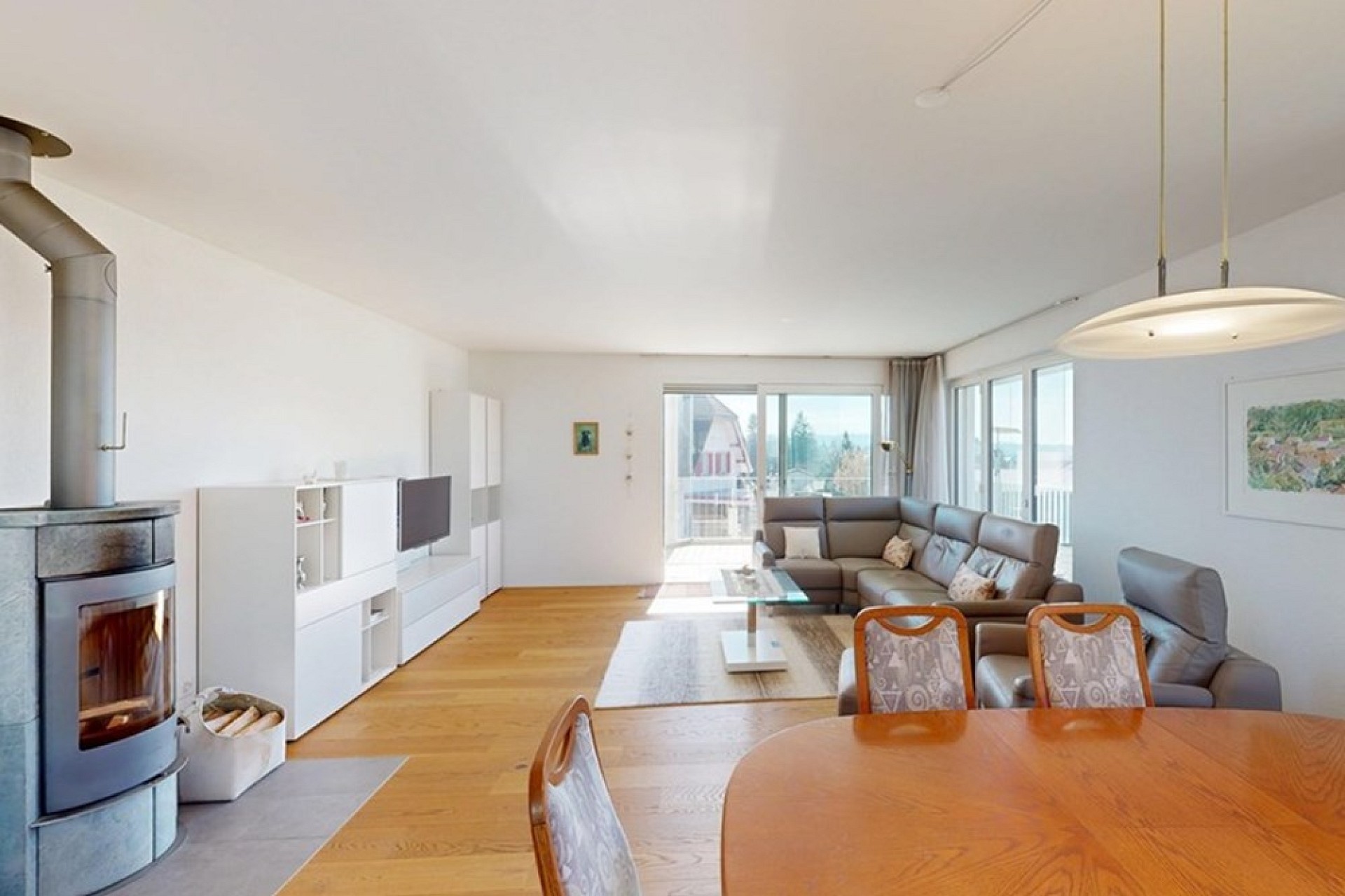 Helles Wohnzimmer mit Kamin und Balkonblick