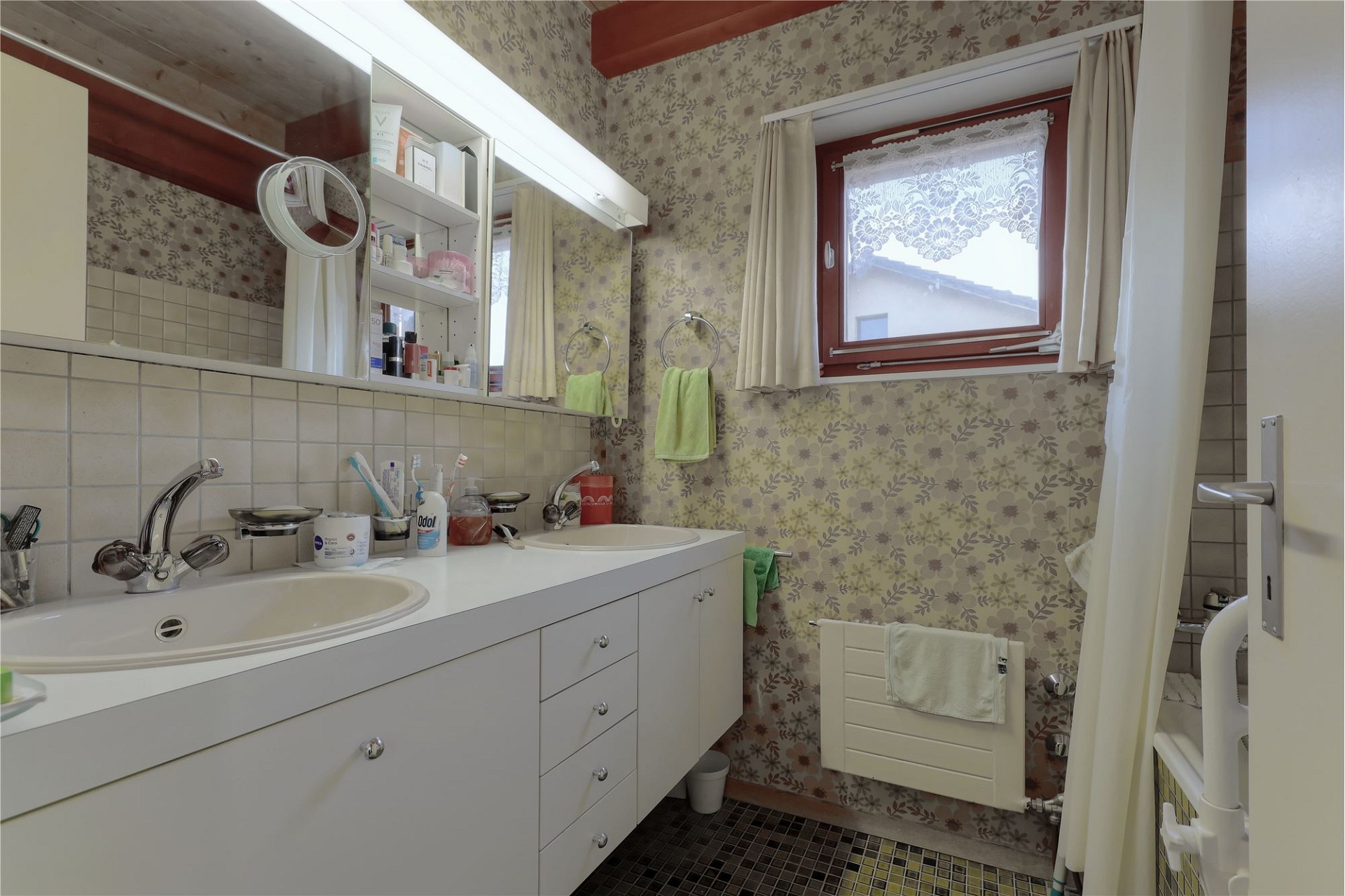 Badezimmer mit Doppelwaschbecken und Blumentapete