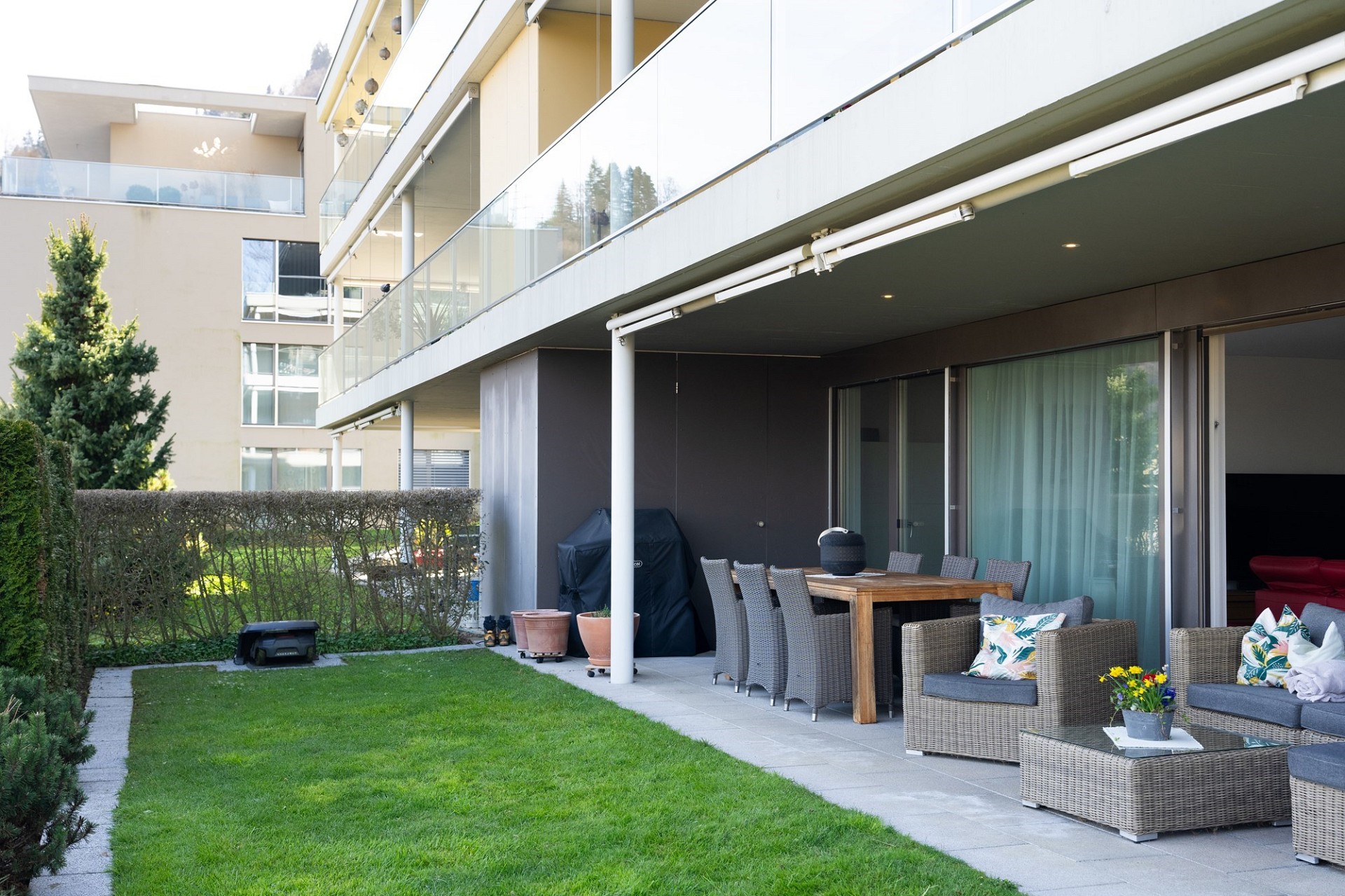 Terrasse mit Garten und moderner Wohnanlage