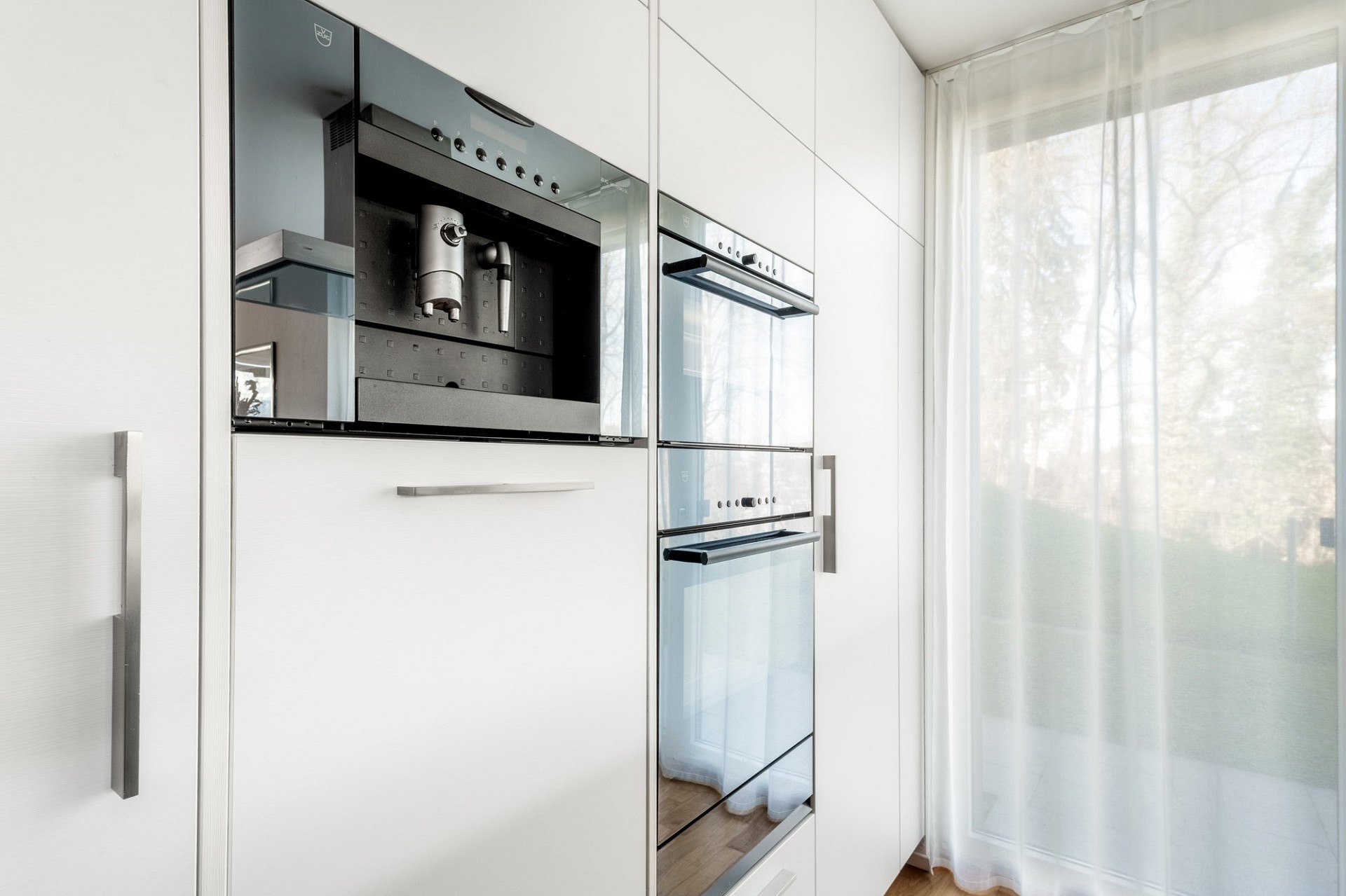 Moderne Einbauküche mit weißen Hochglanzfronten