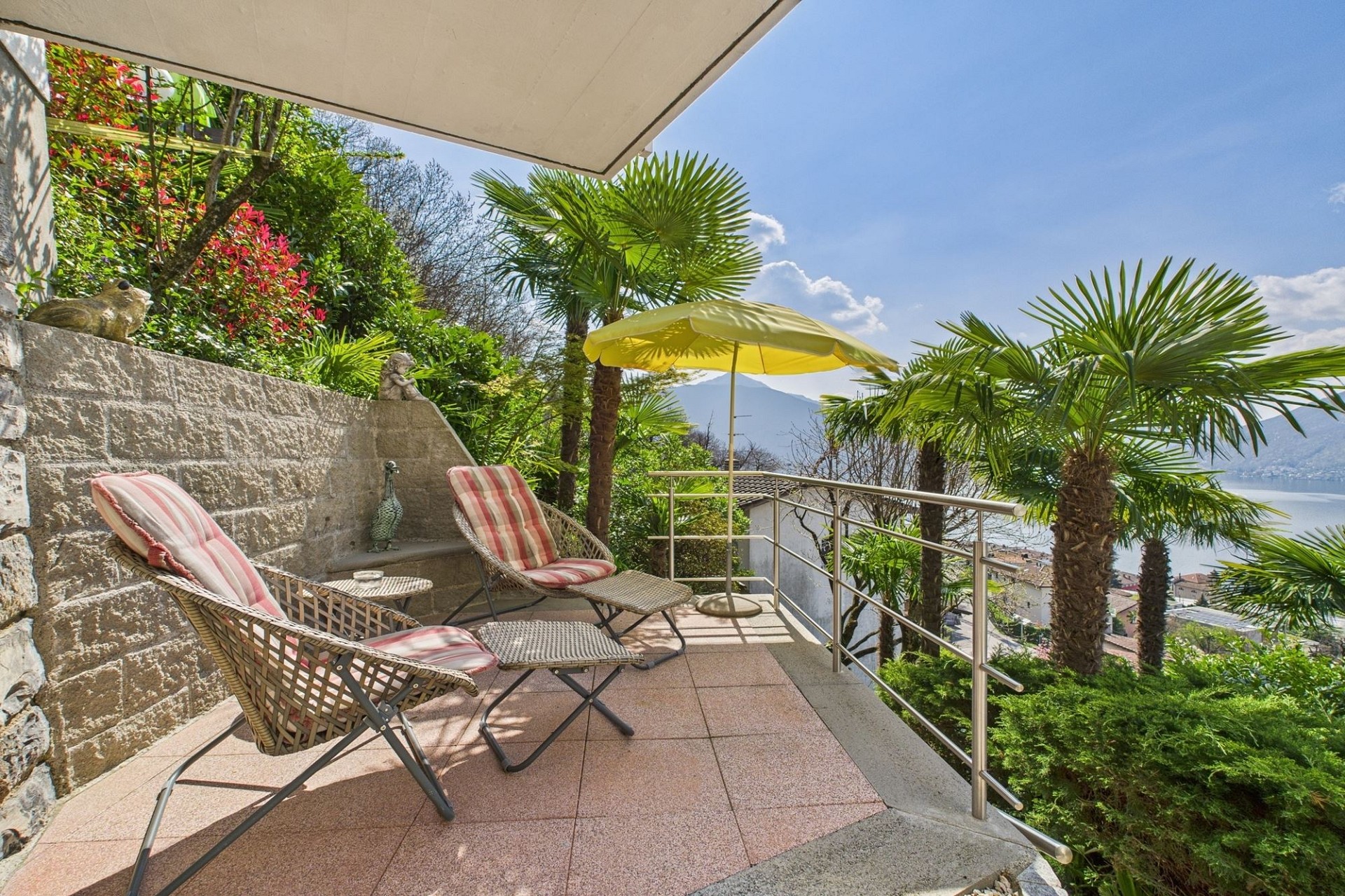 Terrasse mit Seeblick und tropischer Bepflanzung
