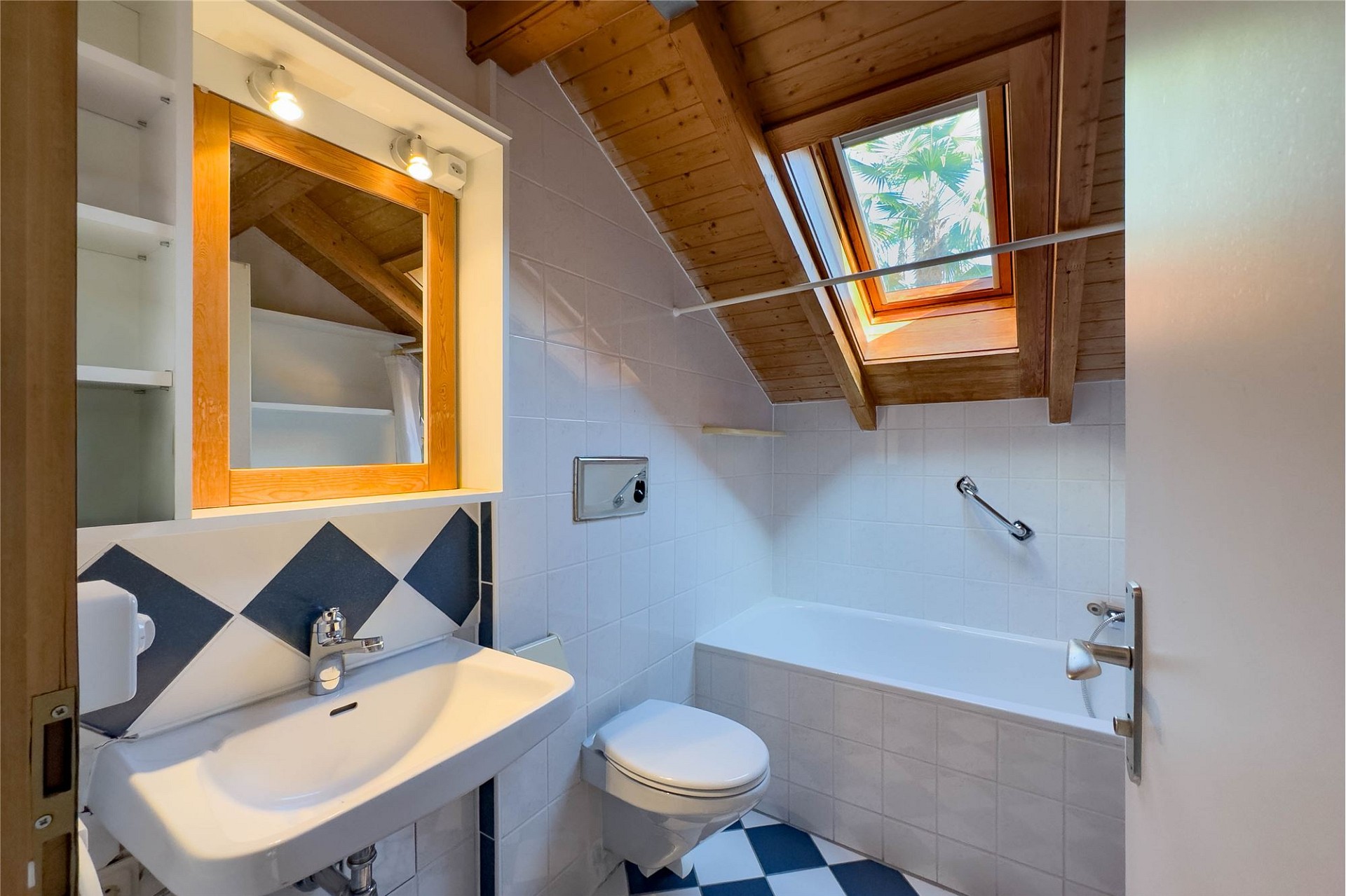 Dachgeschossbad mit Badewanne und Dachfenster