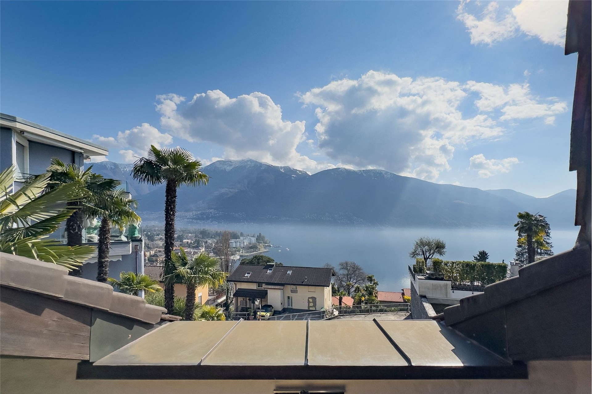 Seeblick mit Bergen und Palmen