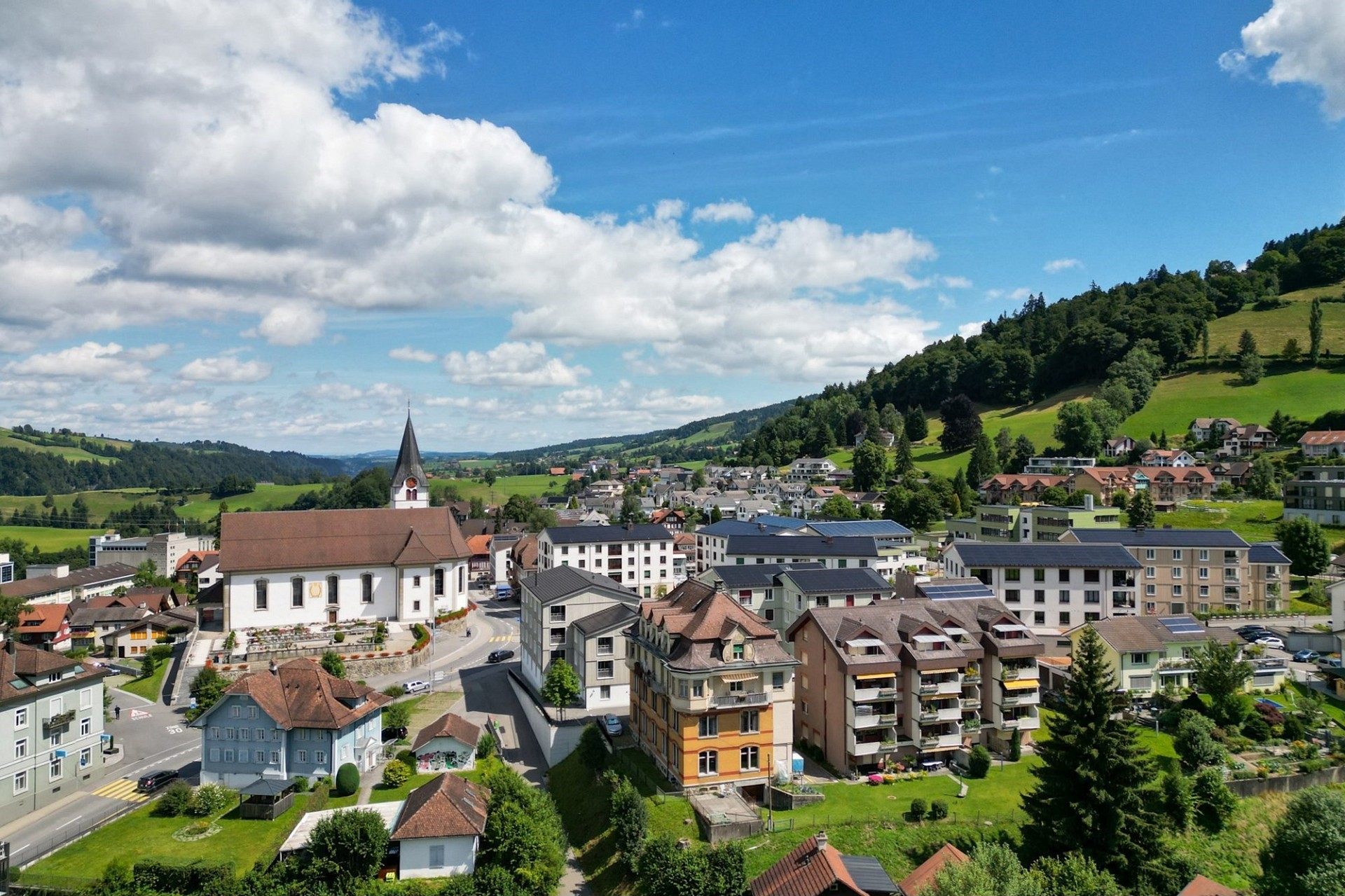 Städtische Panoramaaussicht mit Kirche und Hügeln
