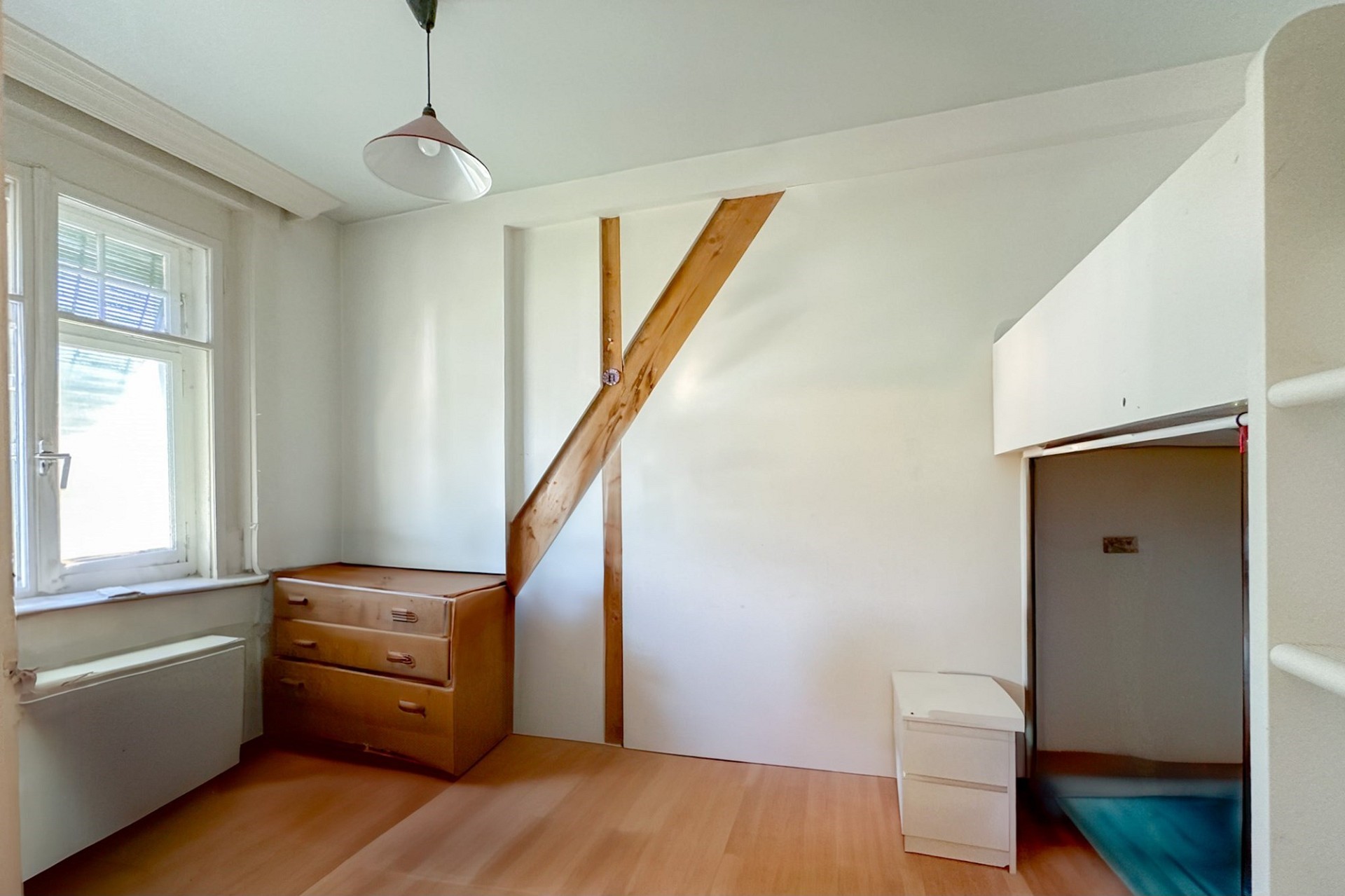 Kleines helles Zimmer mit Fenster und Dachschräge