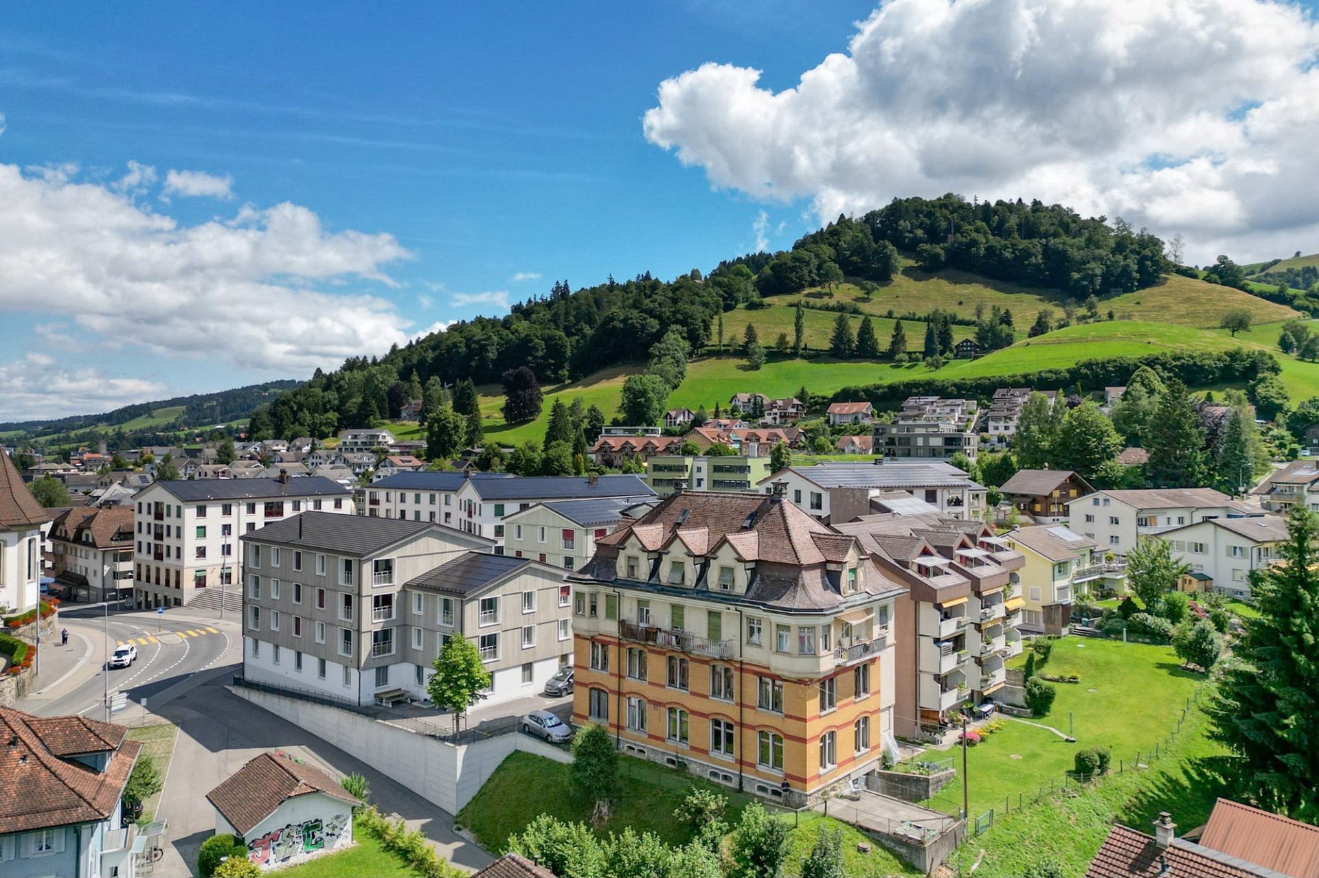 Städtische Ansicht mit Wohngebäuden und grüner Hügellandschaft