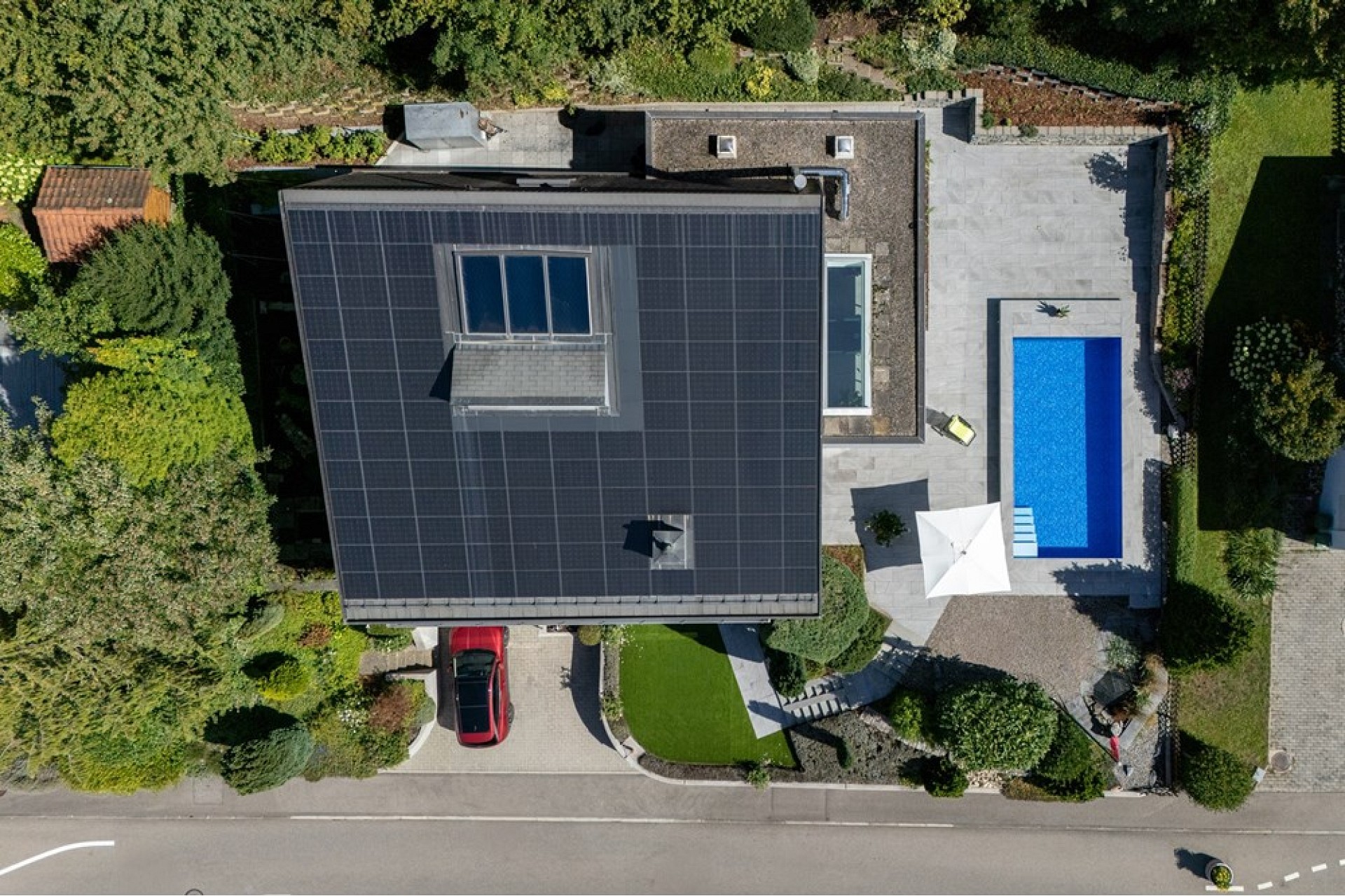 Luftaufnahme eines Hauses mit Pool und Solardach