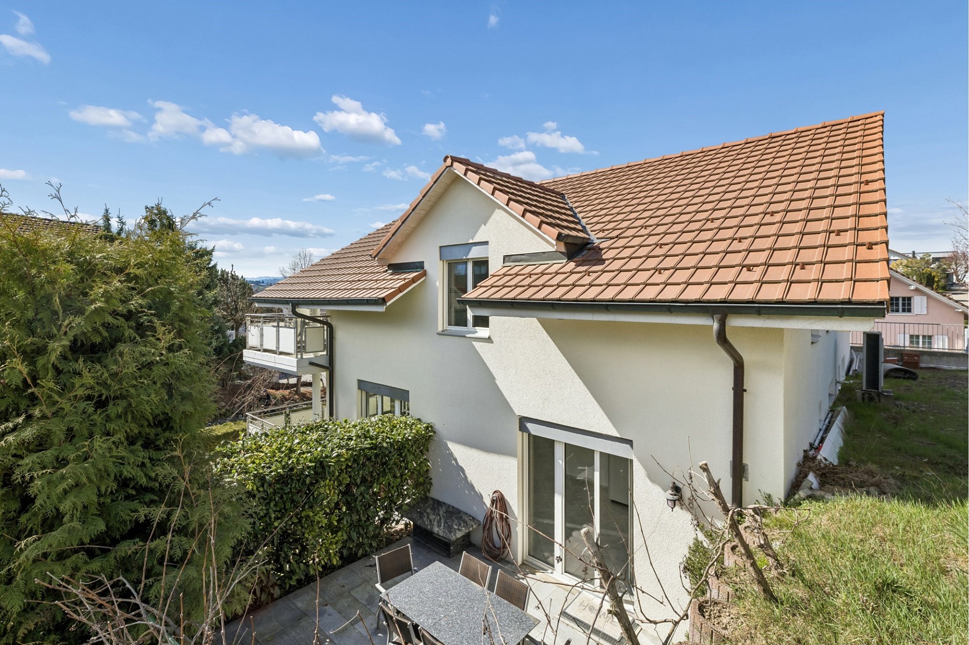Außenansicht eines Einfamilienhauses mit Terrasse und Balkon