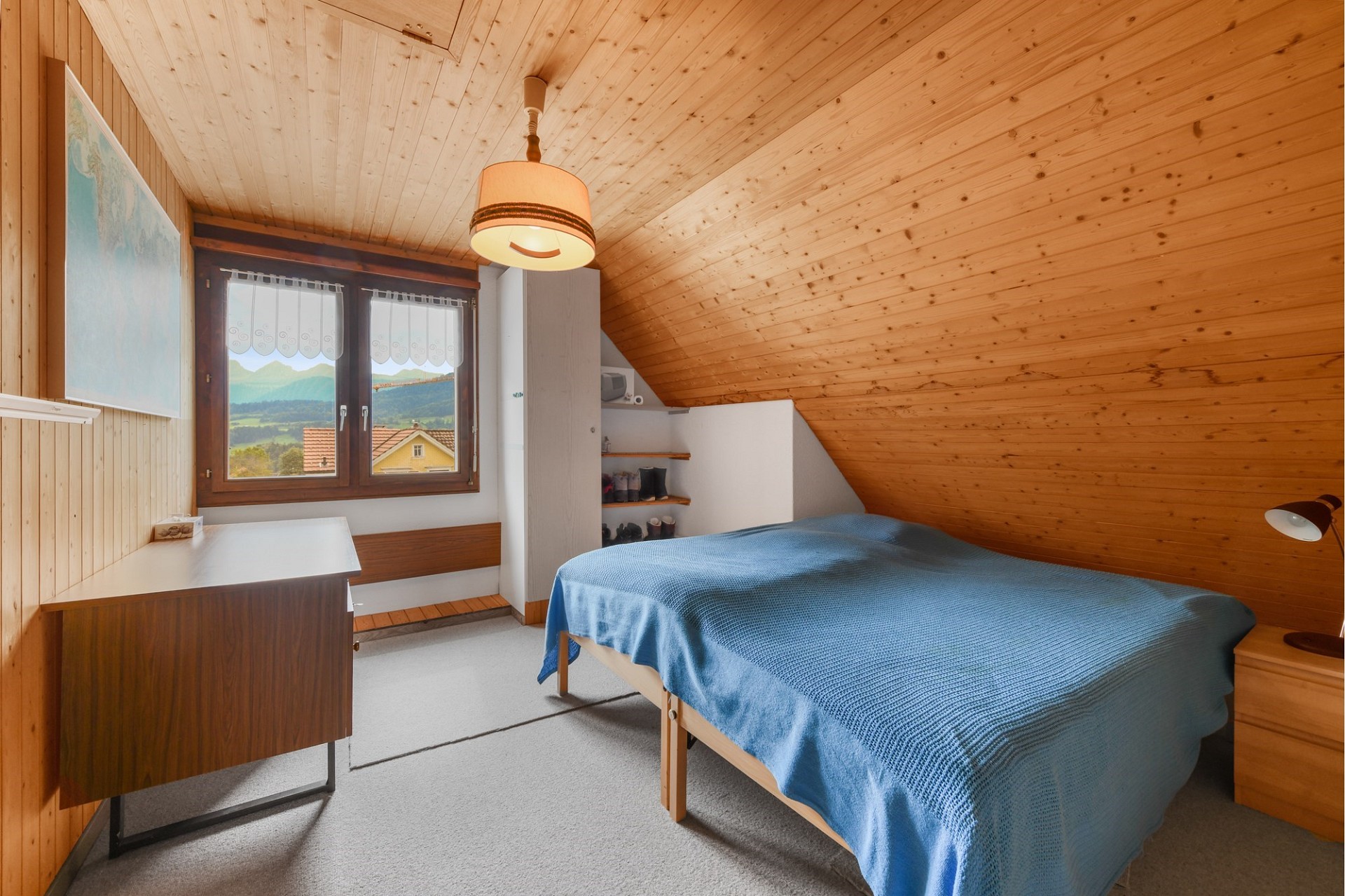 Gemütliches Dachzimmer mit Bett und Bergblick