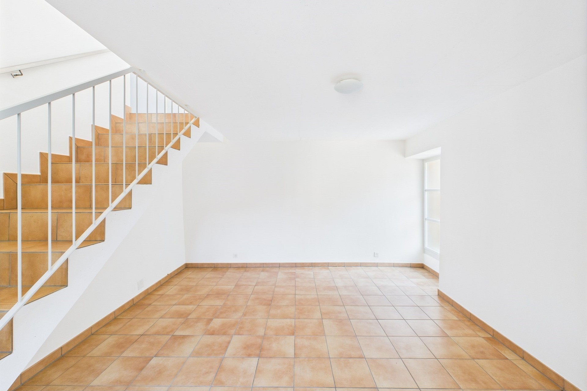 Heller Eingangsbereich mit Treppe und Terrakottafliesen