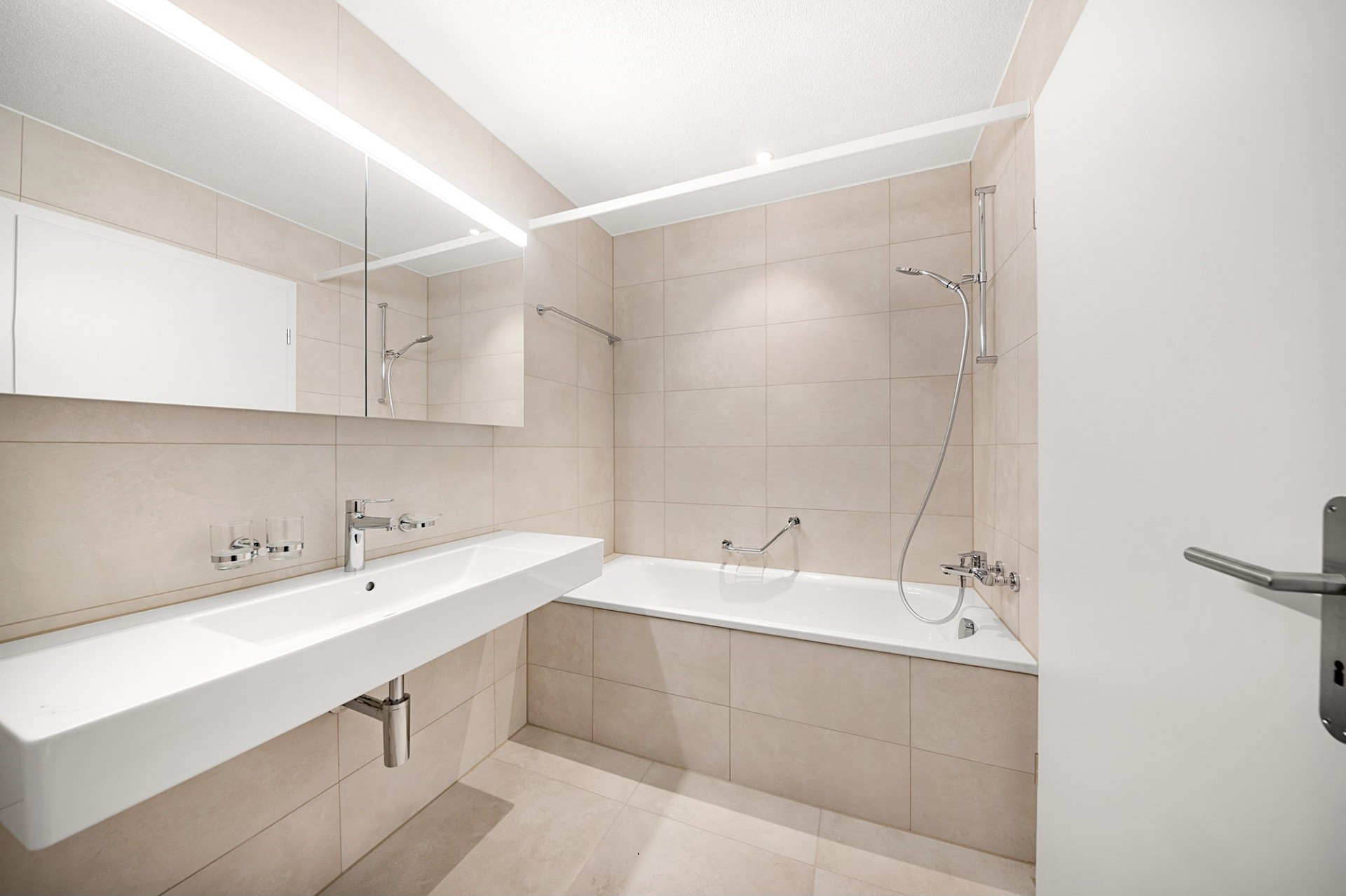 Modernes Badezimmer mit Badewanne und großem Spiegel