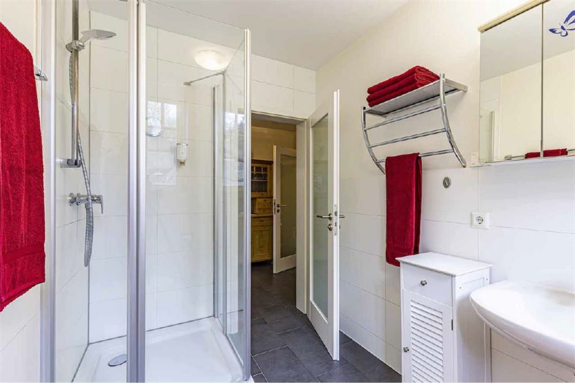 Modernes Badezimmer mit Glasdusche und weißen Fliesen