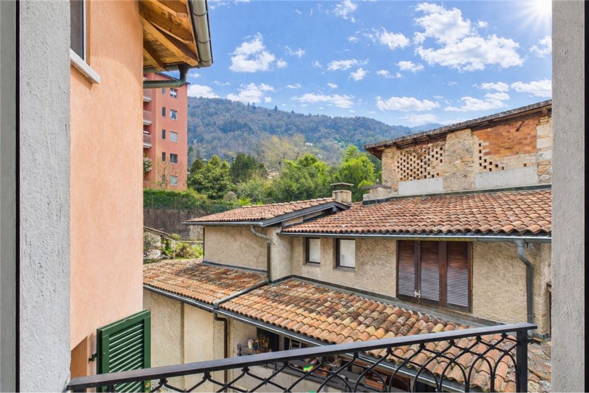 Blick vom Balkon auf mediterrane Dächer und Berge