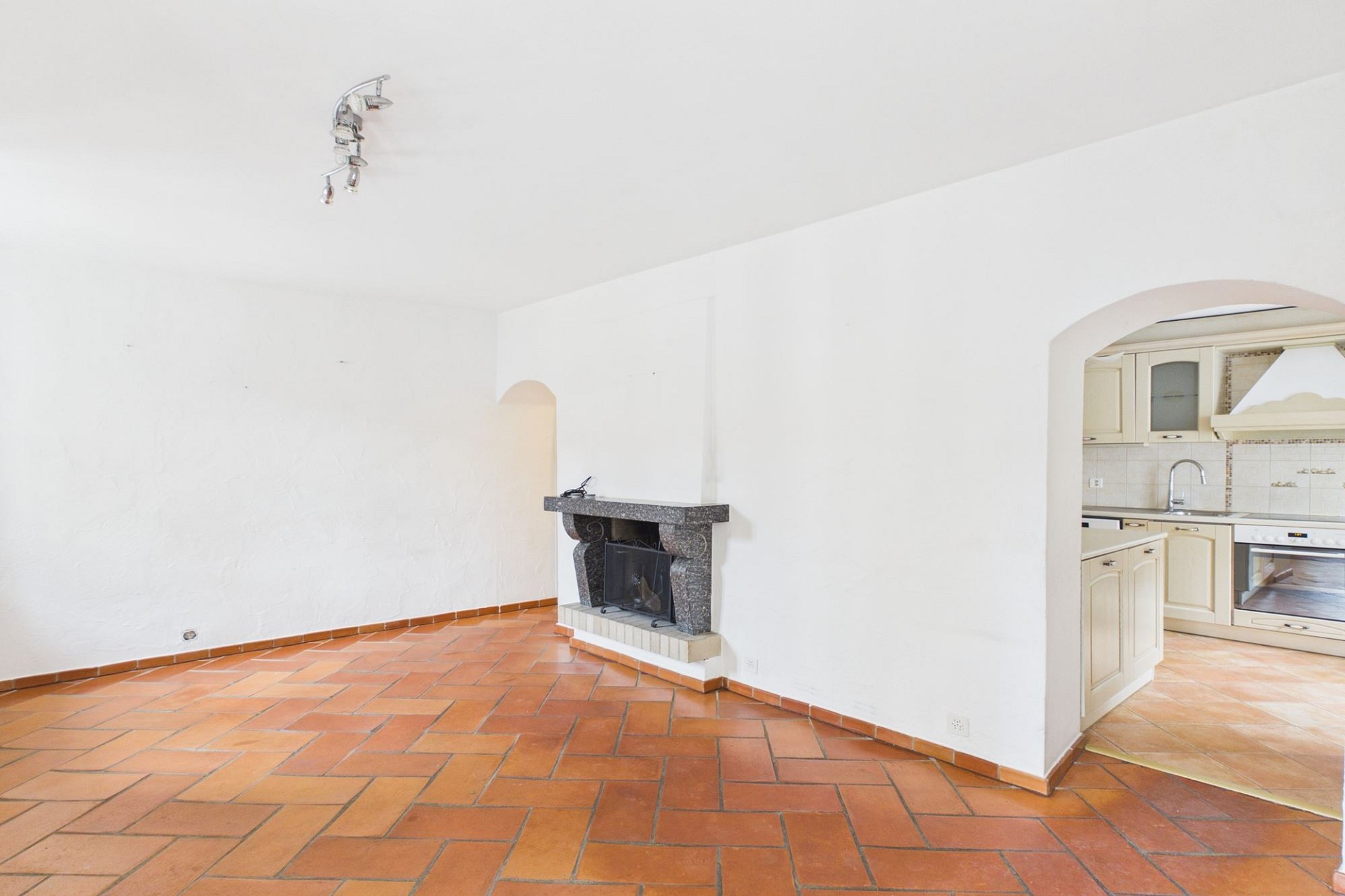 Wohnraum mit Kamin und Durchgang zur Küche