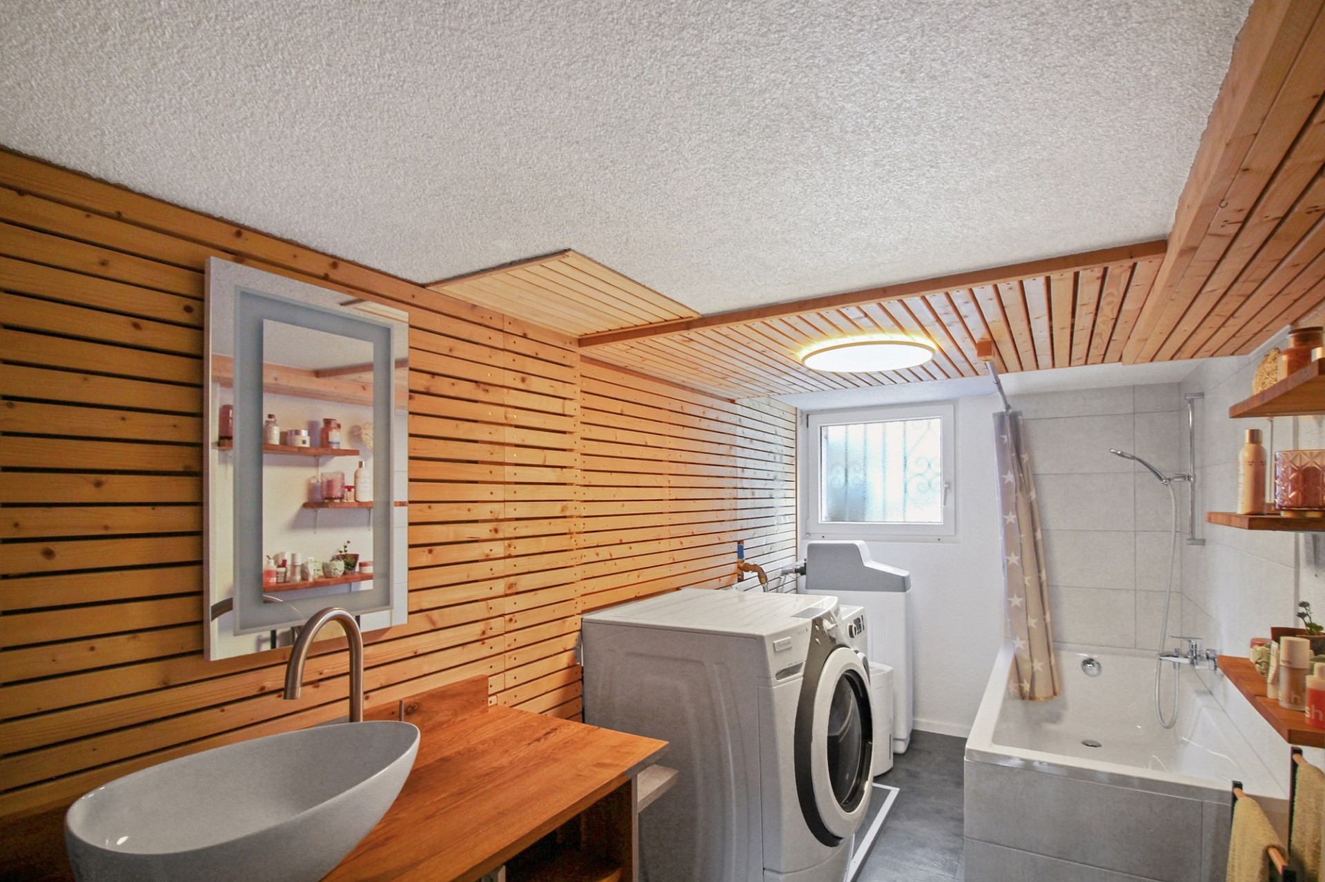 Badezimmer mit Holzverkleidung und Waschbereich