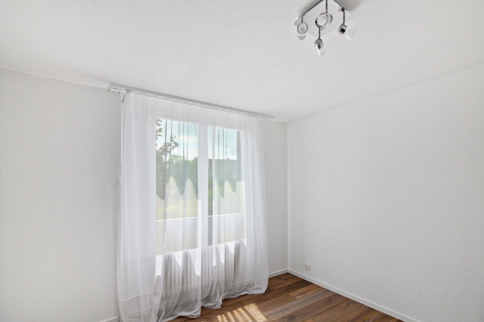 Heller leerer Raum mit Fenster und Vorhang