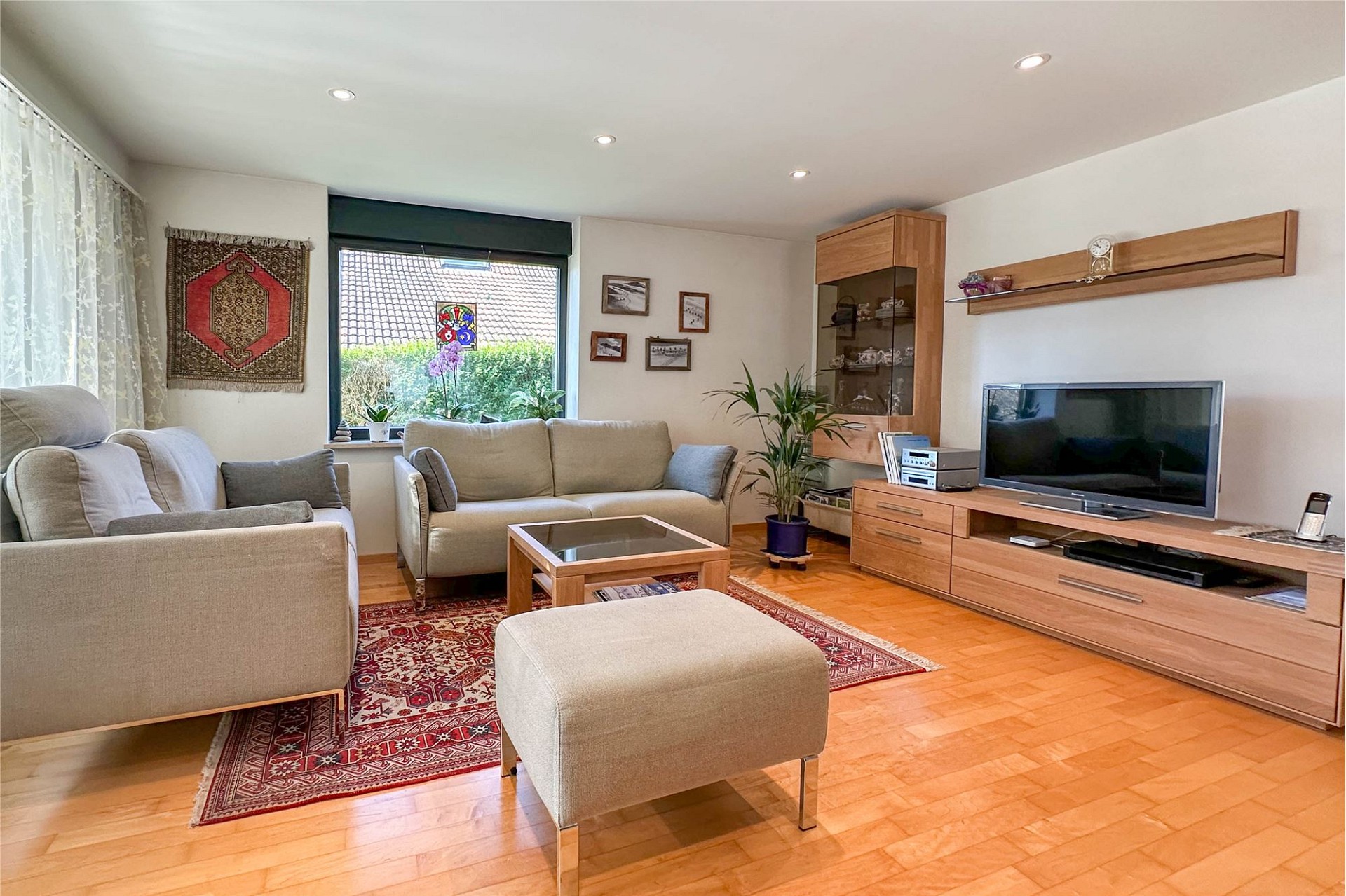 Helles Wohnzimmer mit Holzparkett und Sitzgruppe