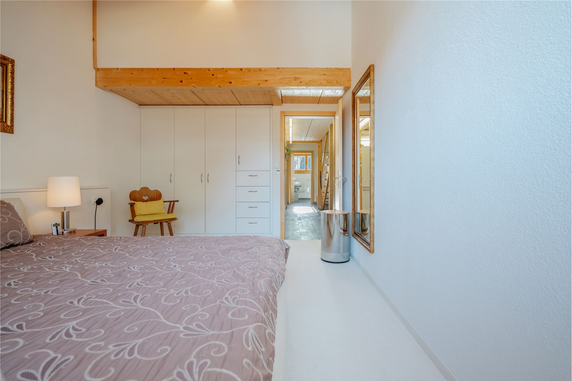 Helles Schlafzimmer mit Holzgalerie und Einbauschrank