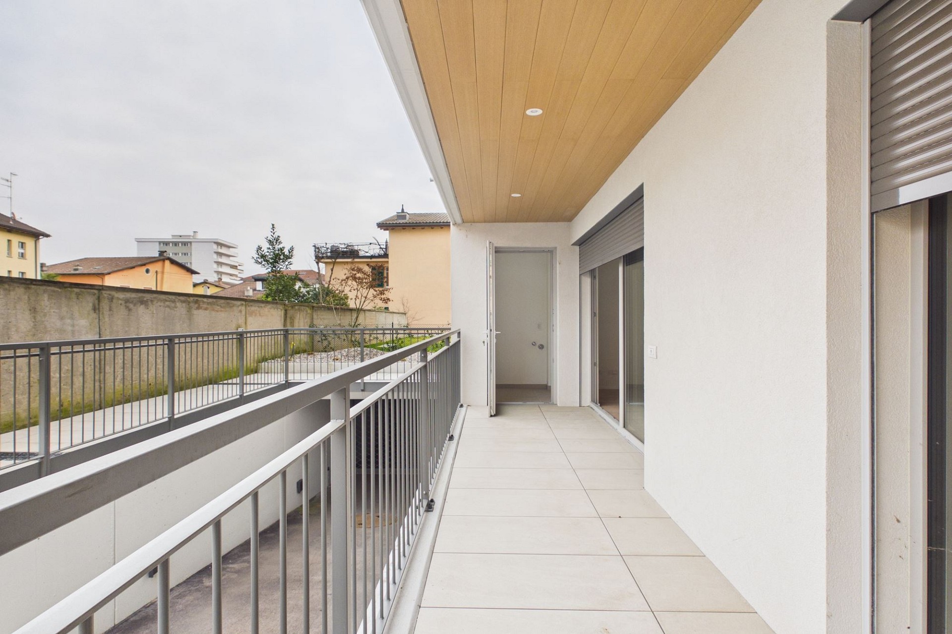 Überdachter Balkon mit Blick ins Wohnumfeld