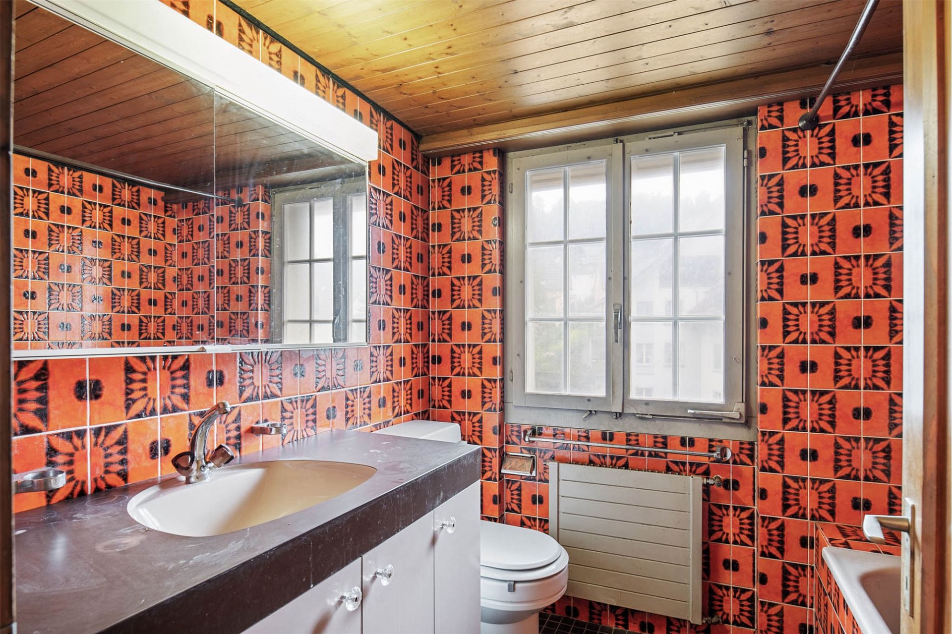 Retro-Badezimmer mit auffälligen orange-schwarzen Fliesen