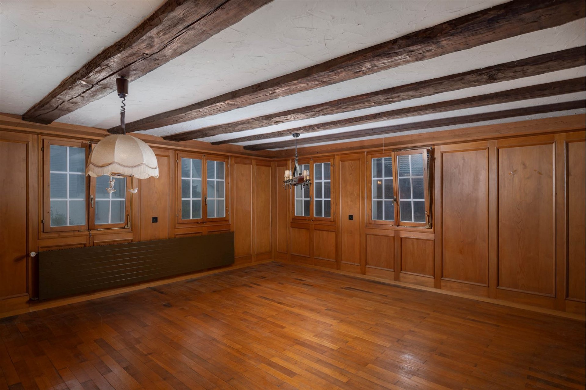 Wohnraum mit Holzvertäfelung und Holzbalkendecke
